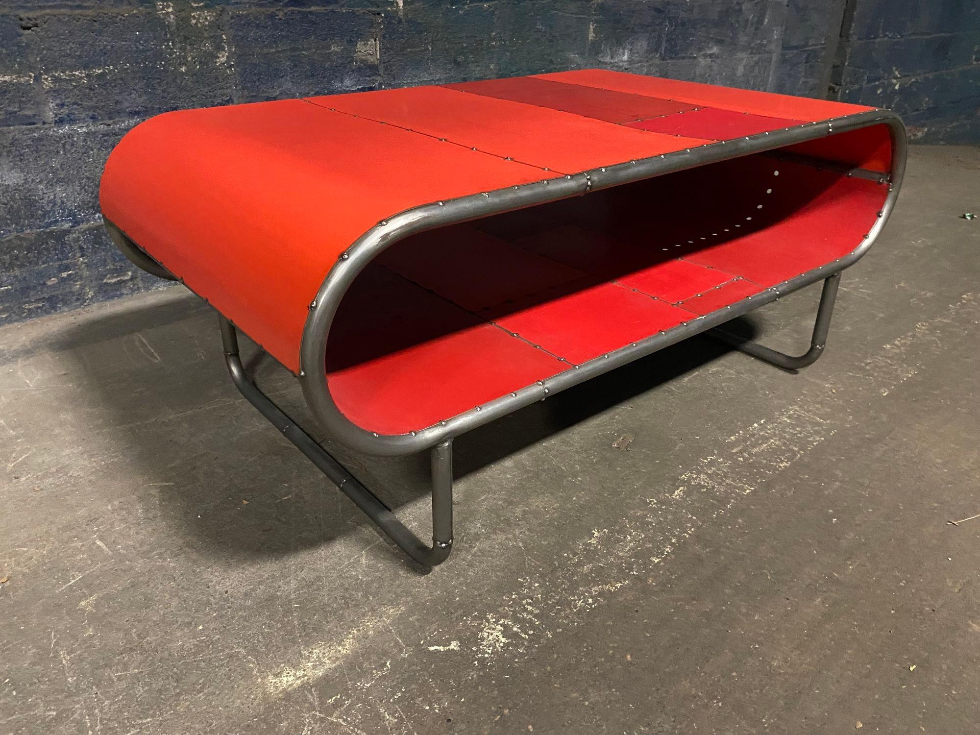 Une belle table à cocktail en forme de capsule fabriquée à partir de tubes d'acier pliés et de tôle peinte récupérée. Elle a environ 20 ans. Elle mesure environ 48