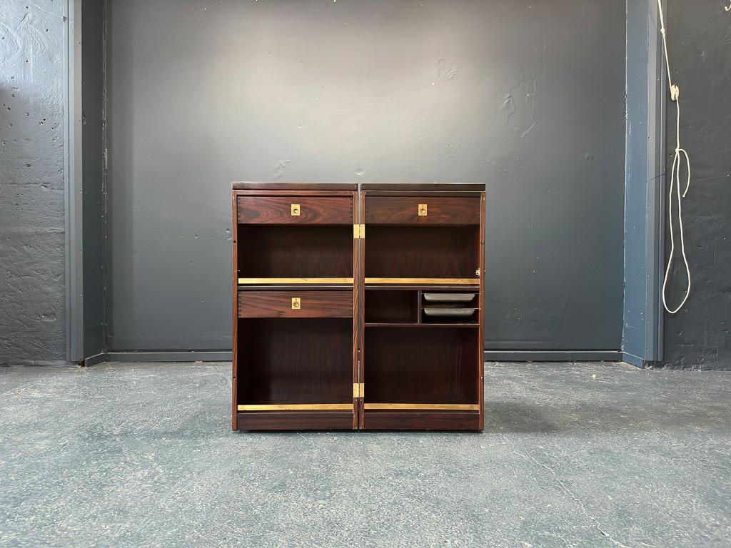 This incredible piece was created by Reno Wahl Iversen a Danish designer and manufactured by Dyrlund in 1960-1969. It is made from hardwood, with a black laminated top on the fold-out bar. Set on casters the bar seamlessly opens to reveal felt-lined