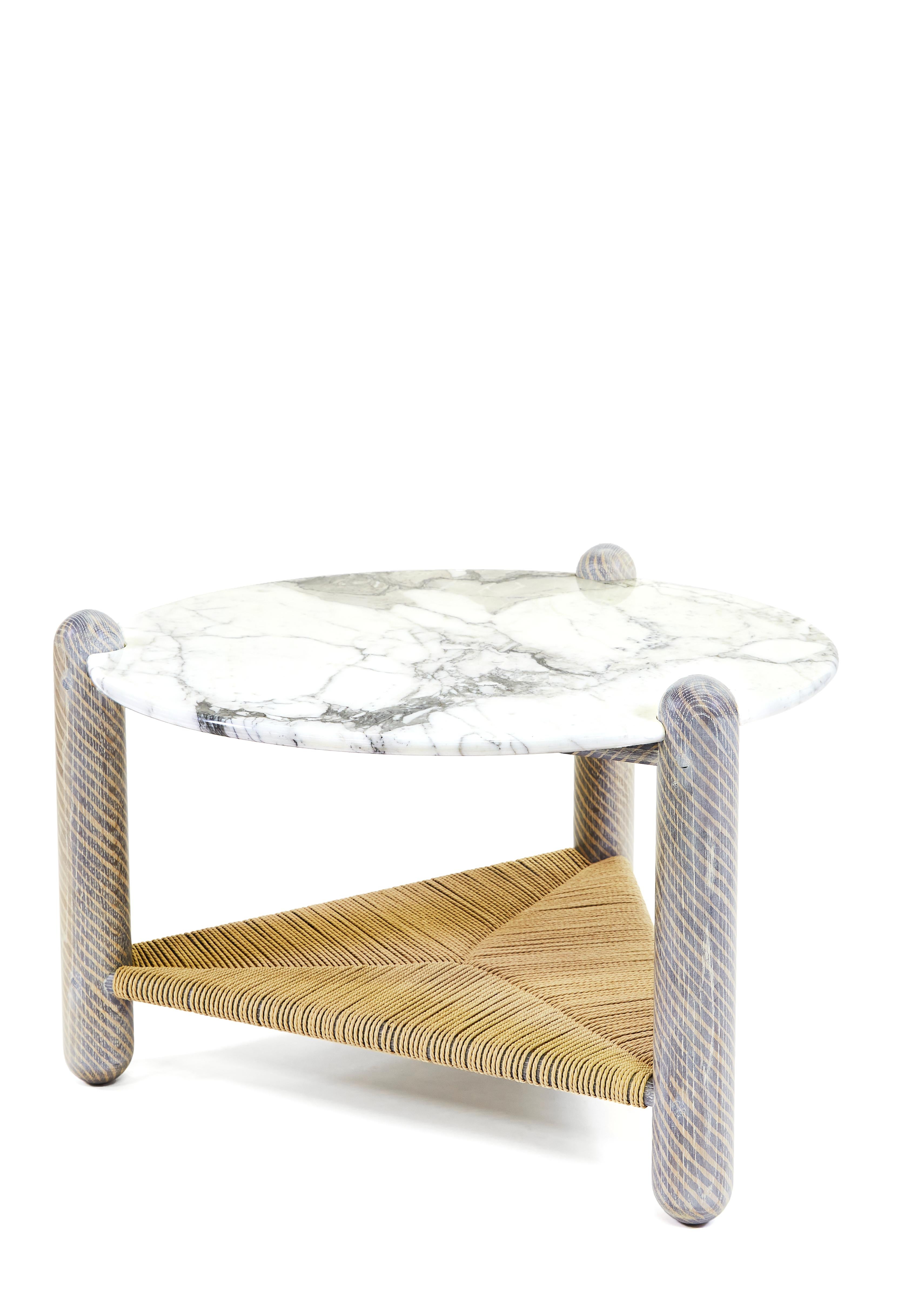 Captain's coffee table by Hamilton Holmes
Oxalino Collection 
Dimensions: 30”D x 18”H
Materials: White oak, Calcatta marble, natural Danish cord and oxidized treatment

These solid oak three-legged tables feature handwoven Danish cord lower