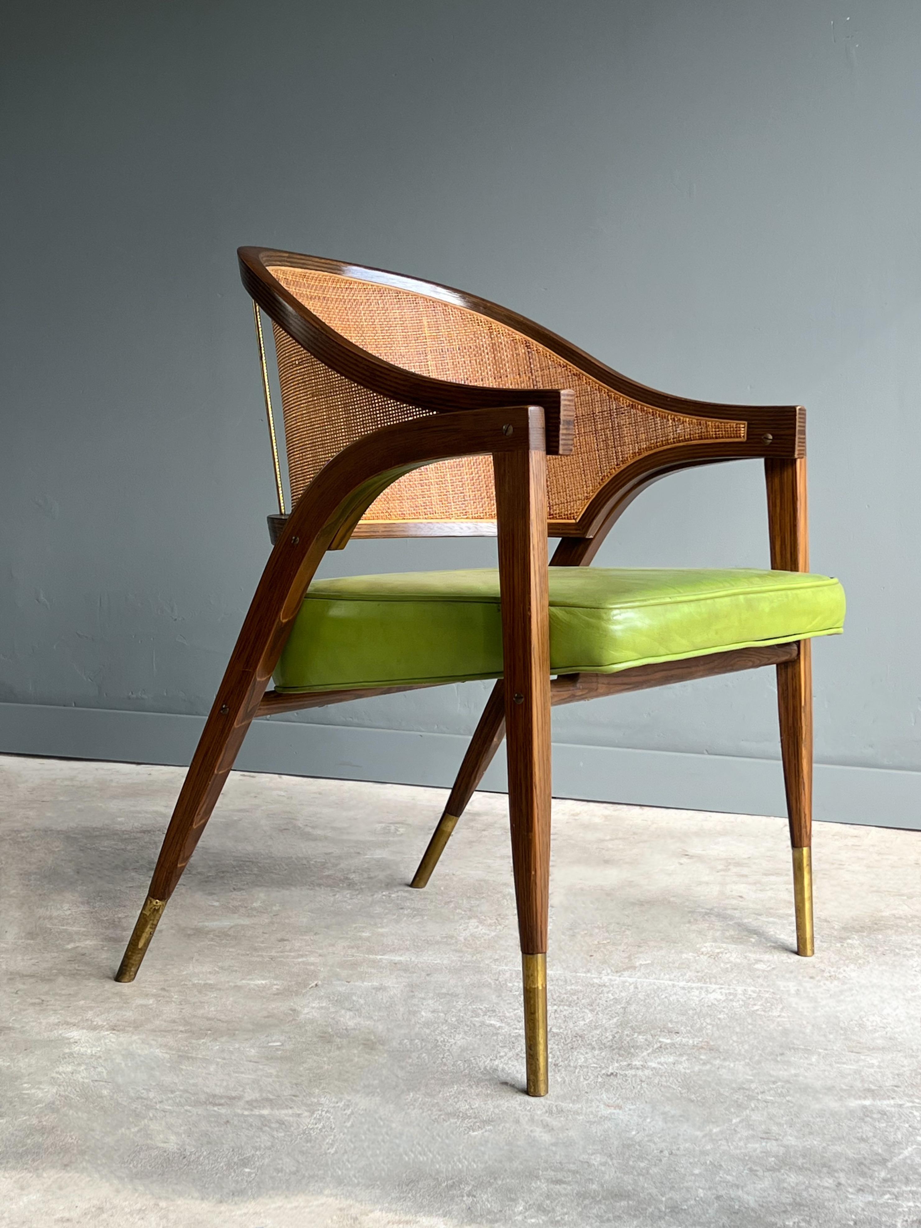 Absolutely lovely captains arm chair by Edward Wormley for Dunbar. Model 5480 may be Wormleys most recognizable designs. Features a gracefully sculpted cane back rest, molded ash frame and brass feet and backrest supports. 

This chair is perfect