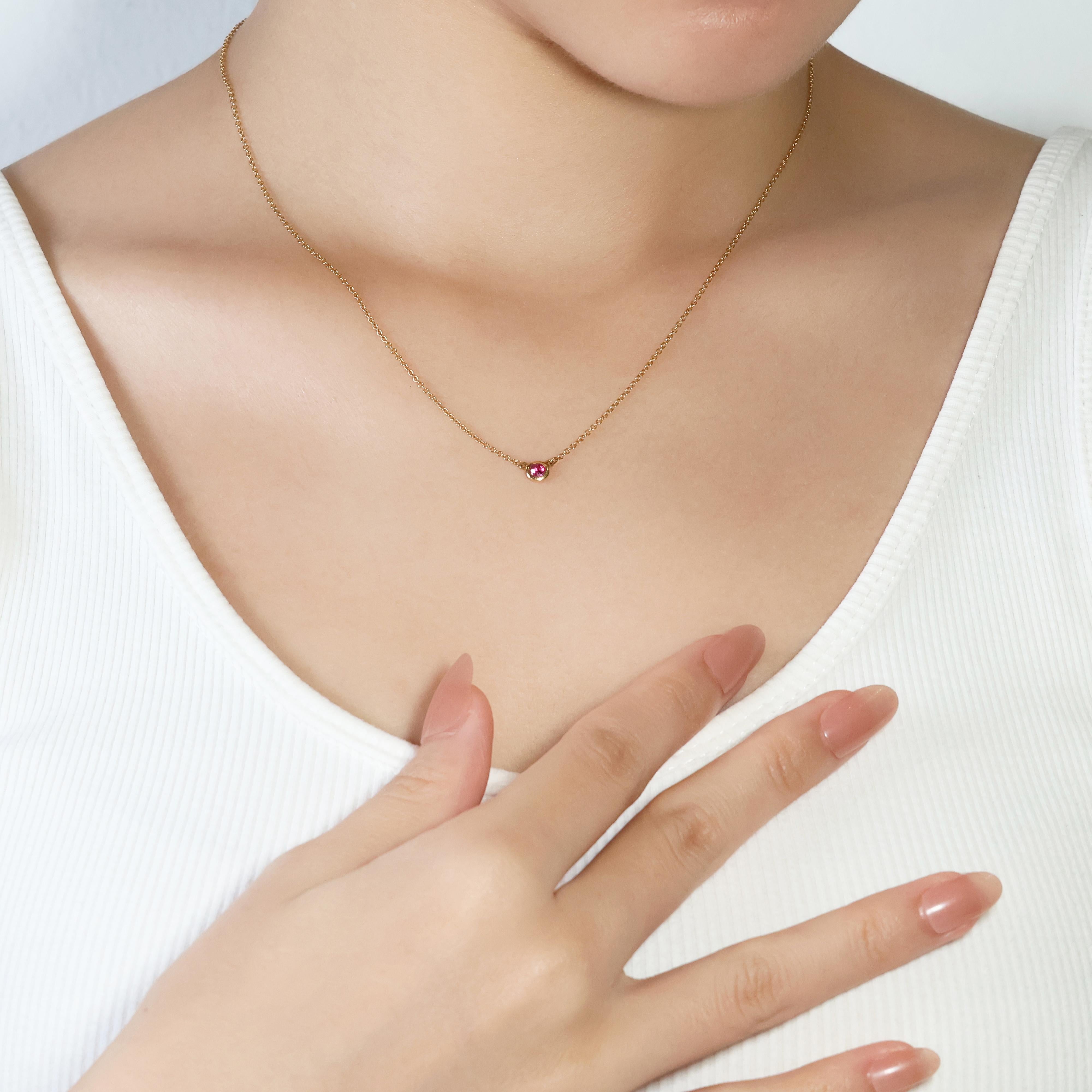 Indulge in timeless elegance with this exquisite Tiffany & Co. 18k yellow gold necklace, boasting a captivating 0.11ct round brilliant red ruby. This luxurious piece, certified and accompanied by its original invoice, showcases the iconic Tiffany