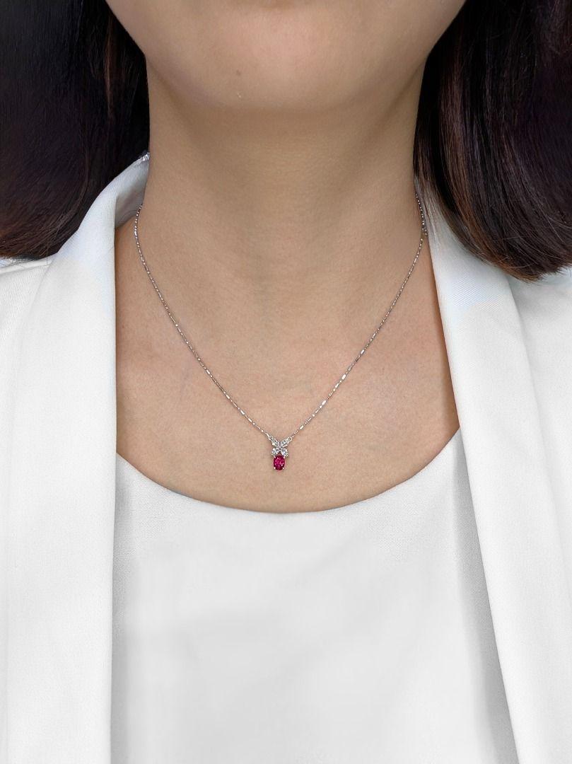 This pre-owned necklace from Larry Jewelry offers a touch of refined sophistication. A vibrant oval-shaped natural ruby, weighing 0.23 carats, serves as a captivating focal point. Enhancing its allure are four marquise-cut natural diamonds, totaling