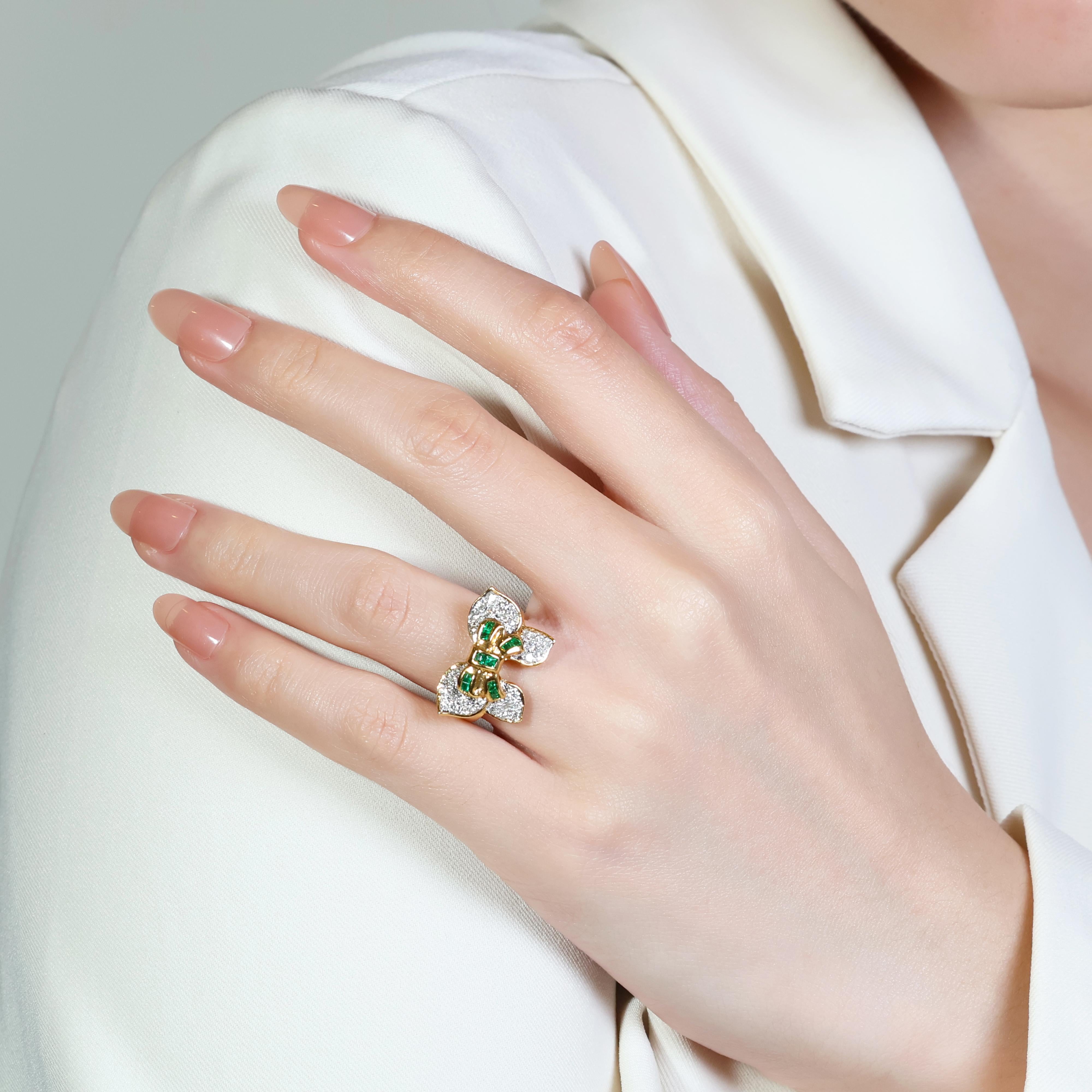 This captivating piece showcases a mesmerizing cluster of 10 emerald-cut emeralds, boasting a captivating green hue.  The rich emeralds (0.25ct total) are beautifully complemented by 30 sparkling round brilliant diamonds (0.55ct total), boasting a