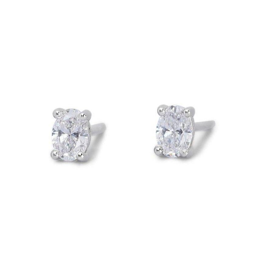 Captivate every glance with these breathtaking earrings, each featuring a dazzling 0.7 carat oval brilliant diamond. Certified by the prestigious Gemological Institute of America (GIA), these flawless gems boast D color and VVS2 clarity for
