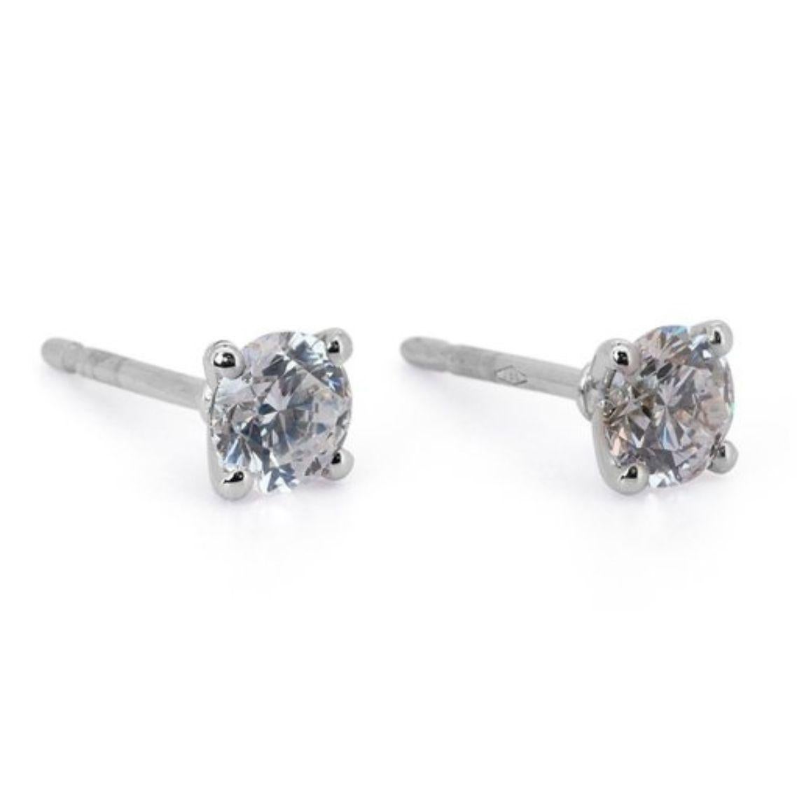Unleash mesmerizing fire with these captivating 1.8 carat diamond stud earrings, handcrafted in lustrous 18K white gold. Each earring features a breathtaking Round Brilliant diamond, boasting an elegant F color and near-flawless VVS1 clarity. The