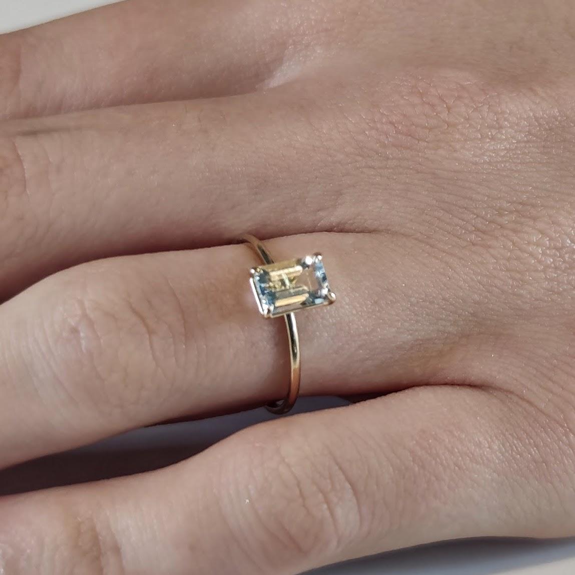 Contemporary Captivating 18K Gold Solitaire Ring featuring a 0.83 Ct. Emerald-Cut Aquamarine For Sale