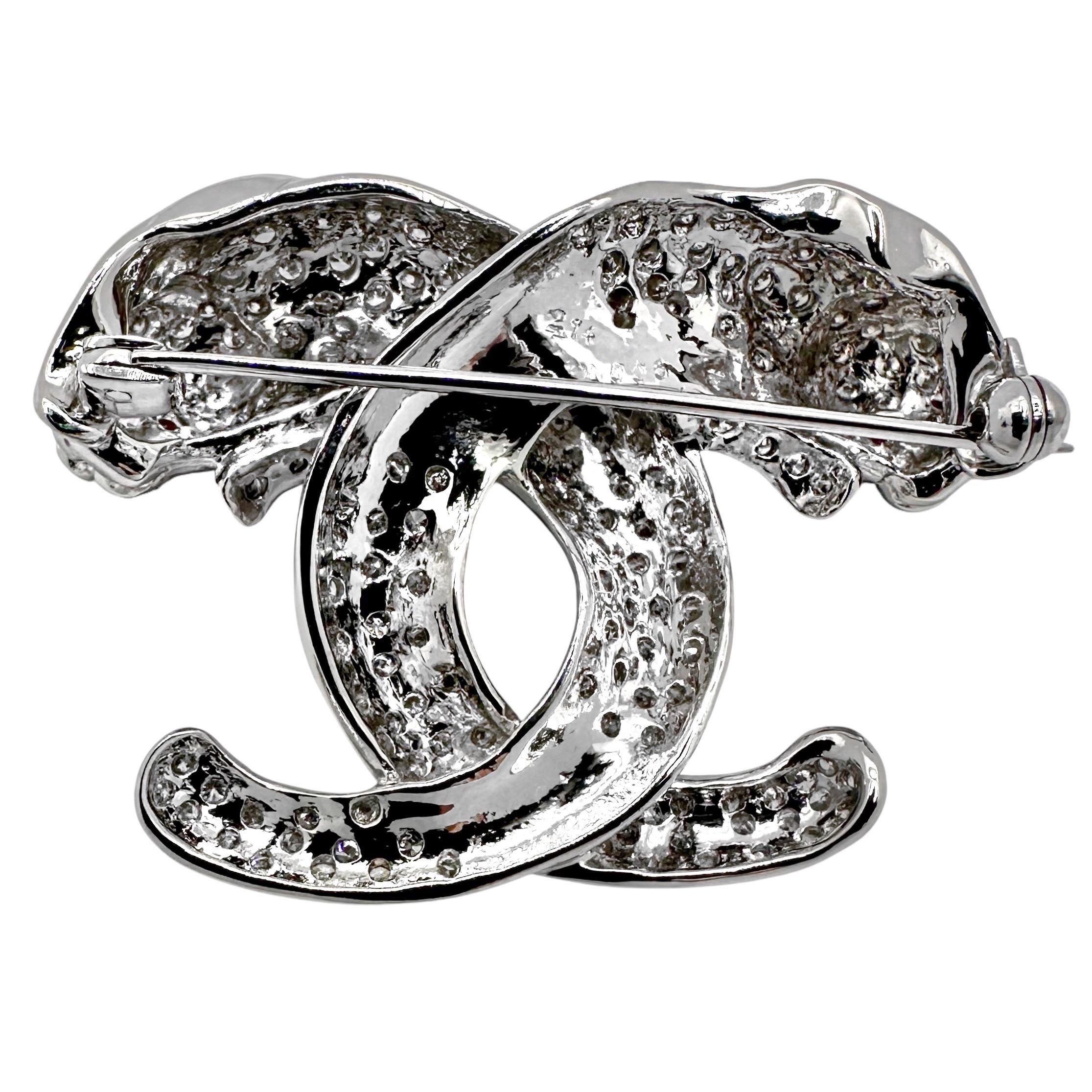 Cette broche vintage en or blanc 18k incrustée de diamants caractérise deux grands et redoutables chats dans la nature. Les quatre yeux rouges vifs en rubis naturel sont captivants. Chaque chat est astucieusement entrelacé avec l'autre dans ce qui