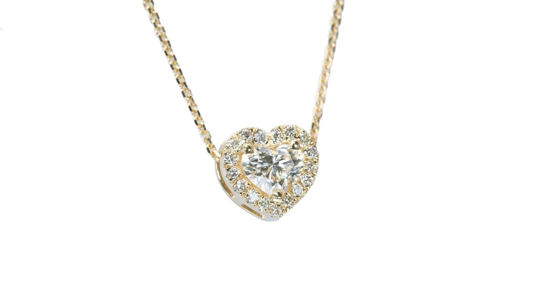 
Introducing our enchanting 18K Yellow Gold Heart Halo Necklace, adorned with a dazzling 1.12 carat centerpiece that radiates elegance and charm. Surrounding this mesmerizing center stone are 16 exquisite round brilliant diamonds, totaling 0.12