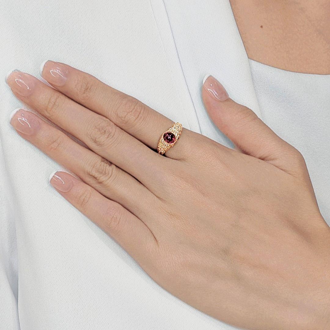 Audacieuse et lumineuse, cette bague accroche le regard grâce à une tourmaline rouge ovale de 0,7 carat taillée en cabochon, riche en couleur et captivante en profondeur. Serti dans de l'or jaune 18 carats étincelant, le ton chaud du métal complète