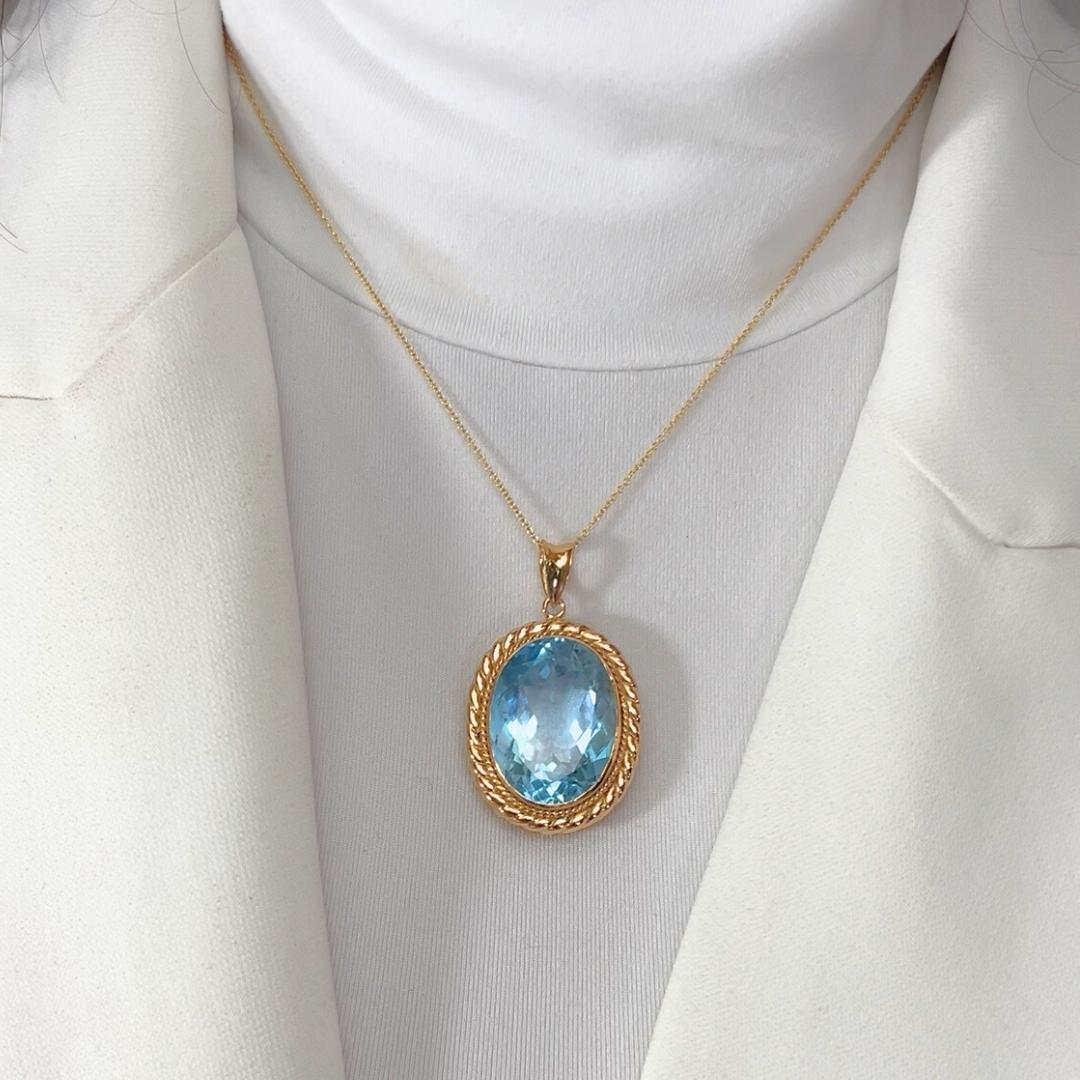 Captivating 38.59ct Topaz Necklace in 18k Yellow Gold - IGI Certified

Exuding elegance and grandeur, this 18K yellow gold necklace showcases a breathtaking 38.59ct oval-cut light blue topaz. Its serene hue captures the essence of tranquility, while
