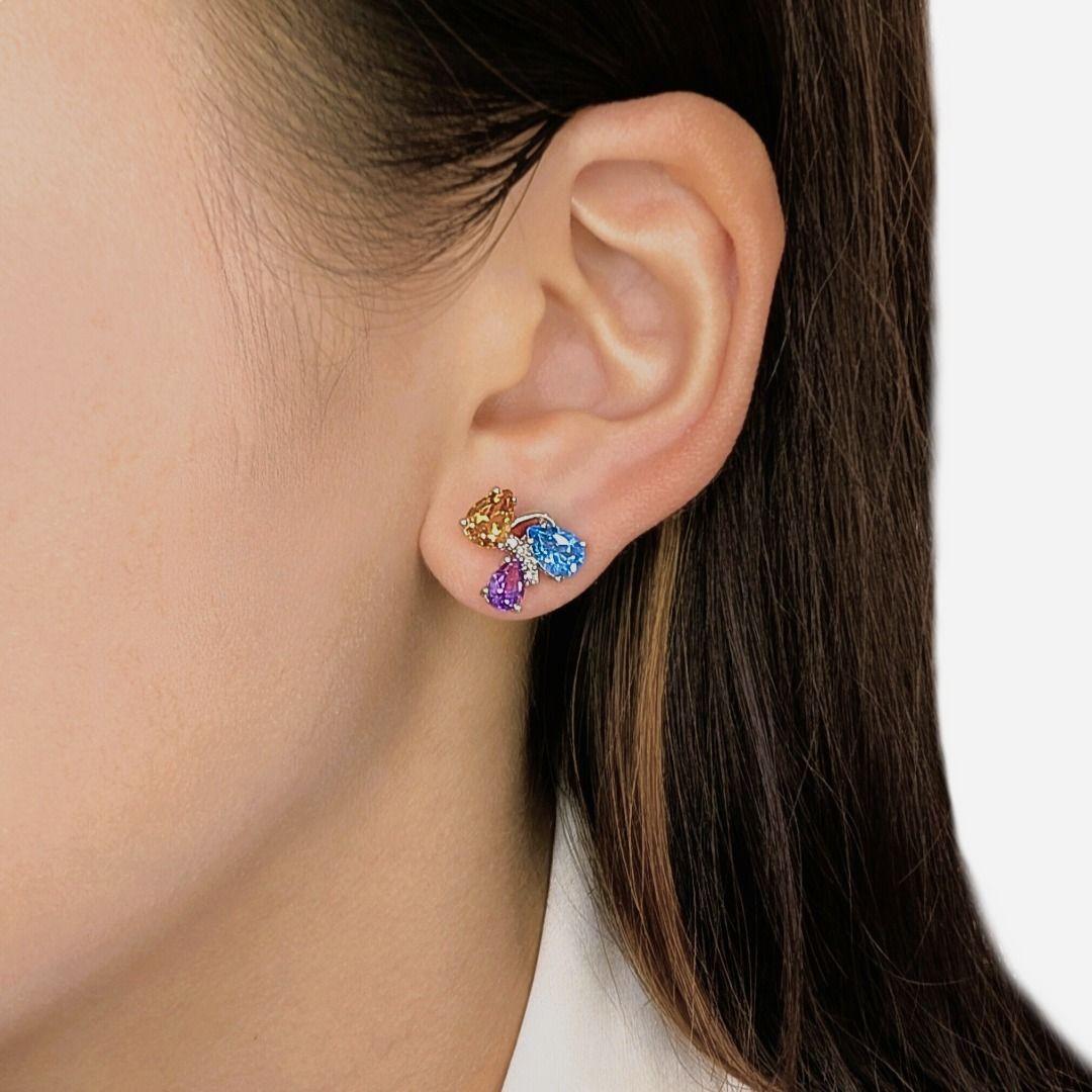 Ajoutez une touche de couleur avec ces boucles d'oreilles ludiques en or blanc 18 carats, composées de topazes bleues étincelantes, de citrines dorées et d'améthystes violettes, élégamment taillées en poire. Agrémentée de diamants naturels pour plus