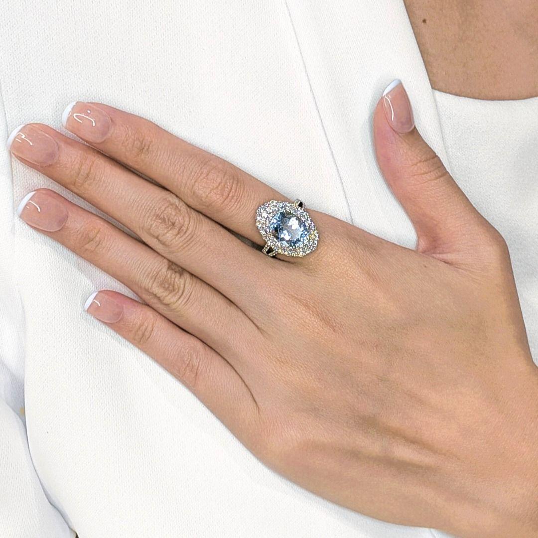 Pièce maîtresse à couper le souffle, cette bague est centrée sur une lumineuse aigue-marine ovale de 4,18ct dans une teinte bleu clair sereine, rayonnant d'élégance et de sophistication. Autour de la pièce maîtresse, 78 diamants naturels ronds