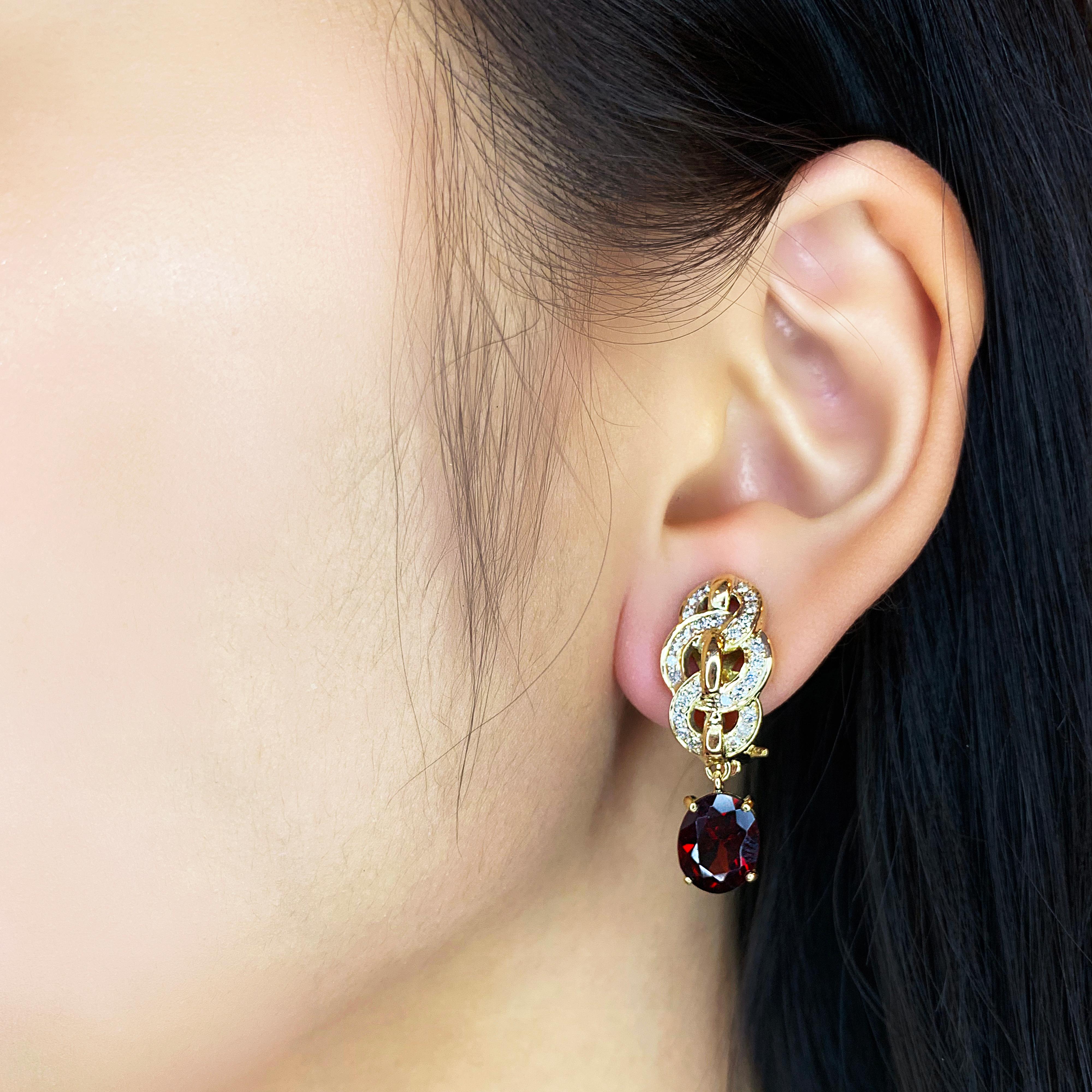 Rehaussez votre élégance avec ces superbes boucles d'oreilles en or jaune 14 carats, ornées de deux captivantes pierres de grenat de forme ovale. L'un des grenats pèse 2,71ct et l'autre 2,73ct, tous deux présentant une riche teinte rouge. Les