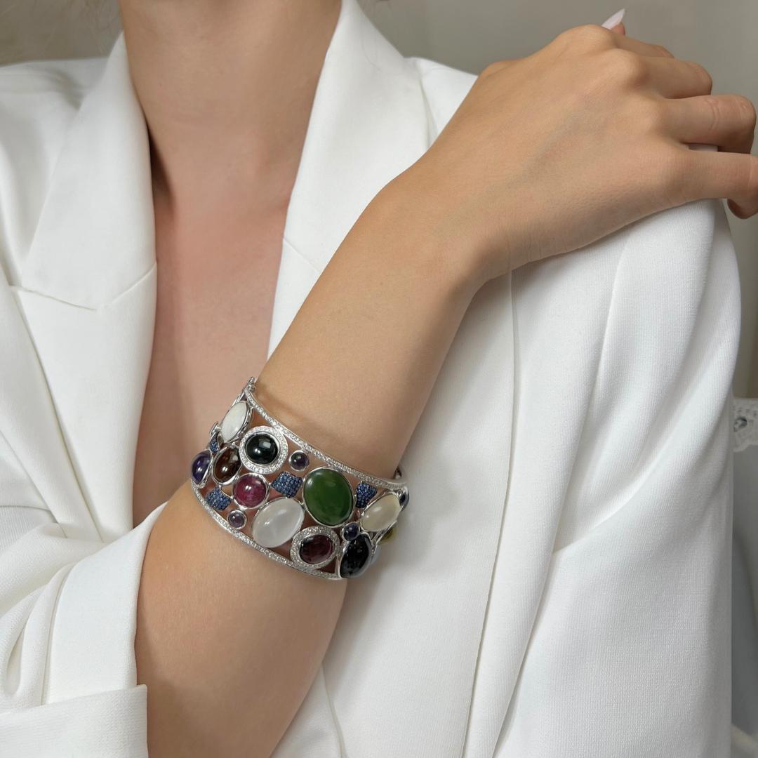 Captivating 77.63ct Mix Natural Gemstones and Diamonds Bangle in 14k White Gold - IGI Certified

This stunning 14k white gold bangle showcases a breathtaking 8.06-carat oval Nephrite Jade, surrounded by a brilliant ensemble of precious gemstones.