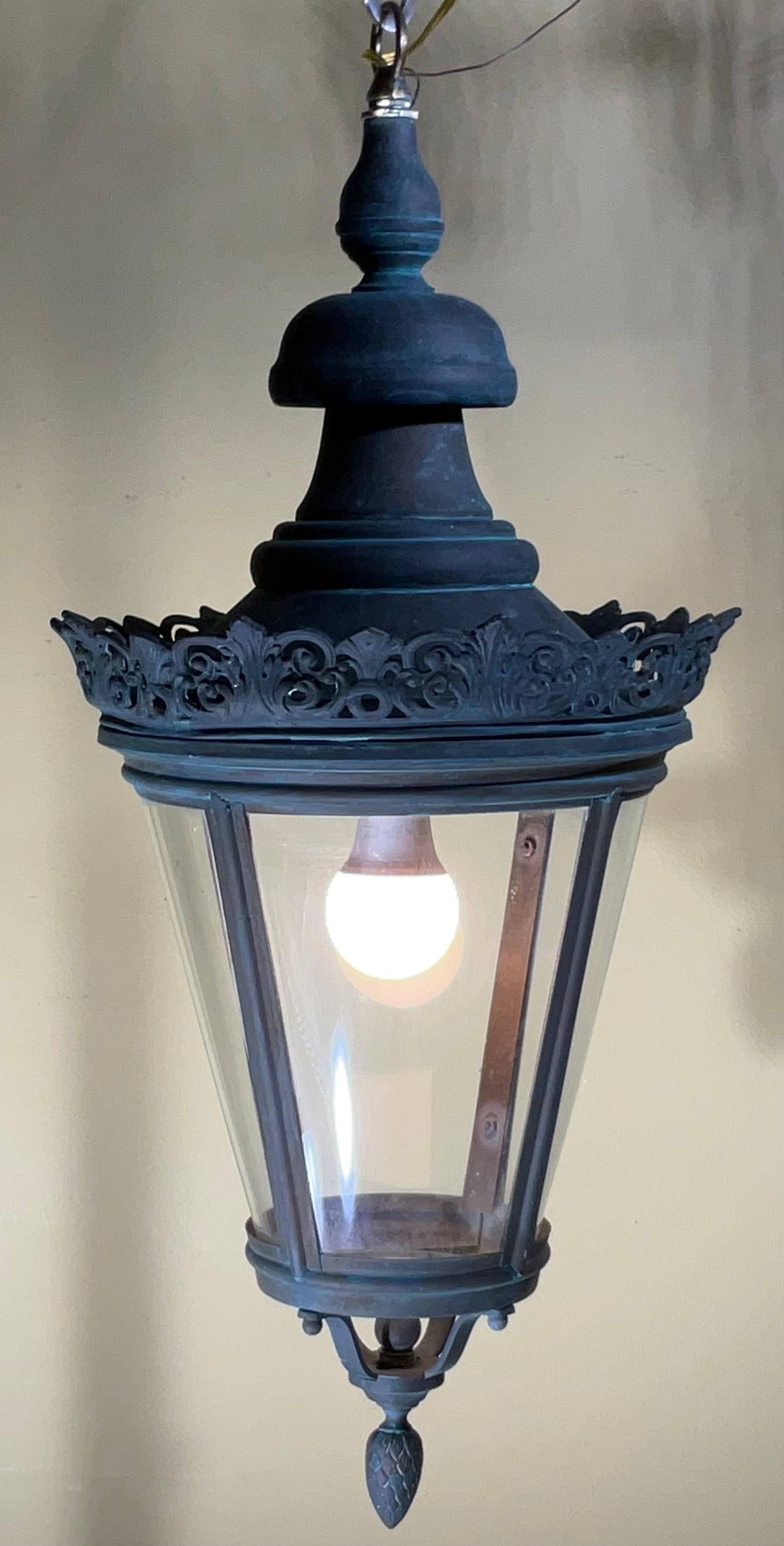 Illuminez votre espace avec une touche d'histoire et d'élégance grâce à cette superbe lanterne antique. Cette pièce captivante présente une riche patine vert-de-gris, qui témoigne de son âge et de son exposition aux éléments, et lui confère un