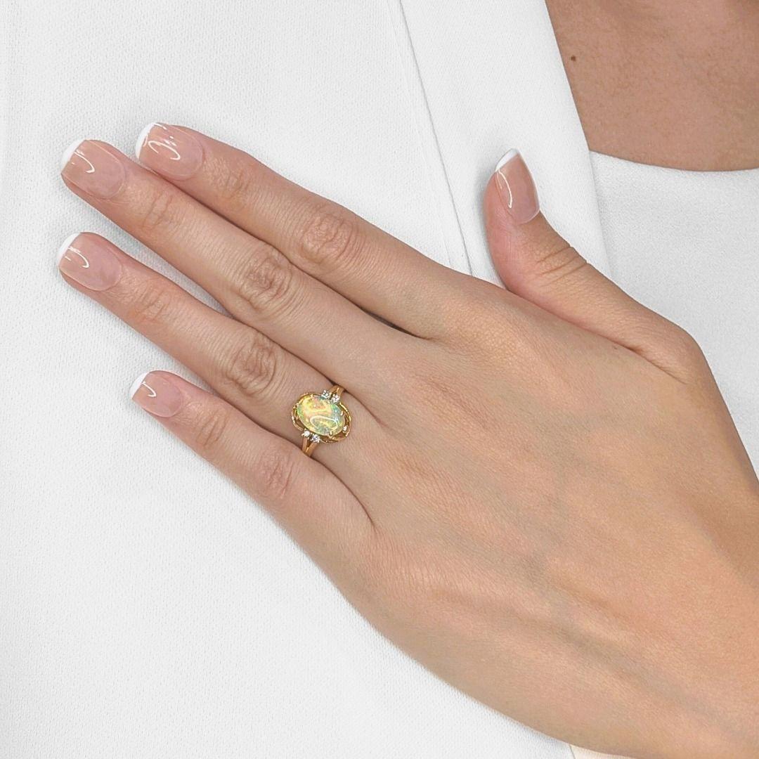A mesmerizing blend of elegance and color, this 20K yellow gold ring features a striking oval-shaped blue opal, radiating an enchanting play of hues with every movement. Enhancing its brilliance are four round brilliant-cut natural diamonds,