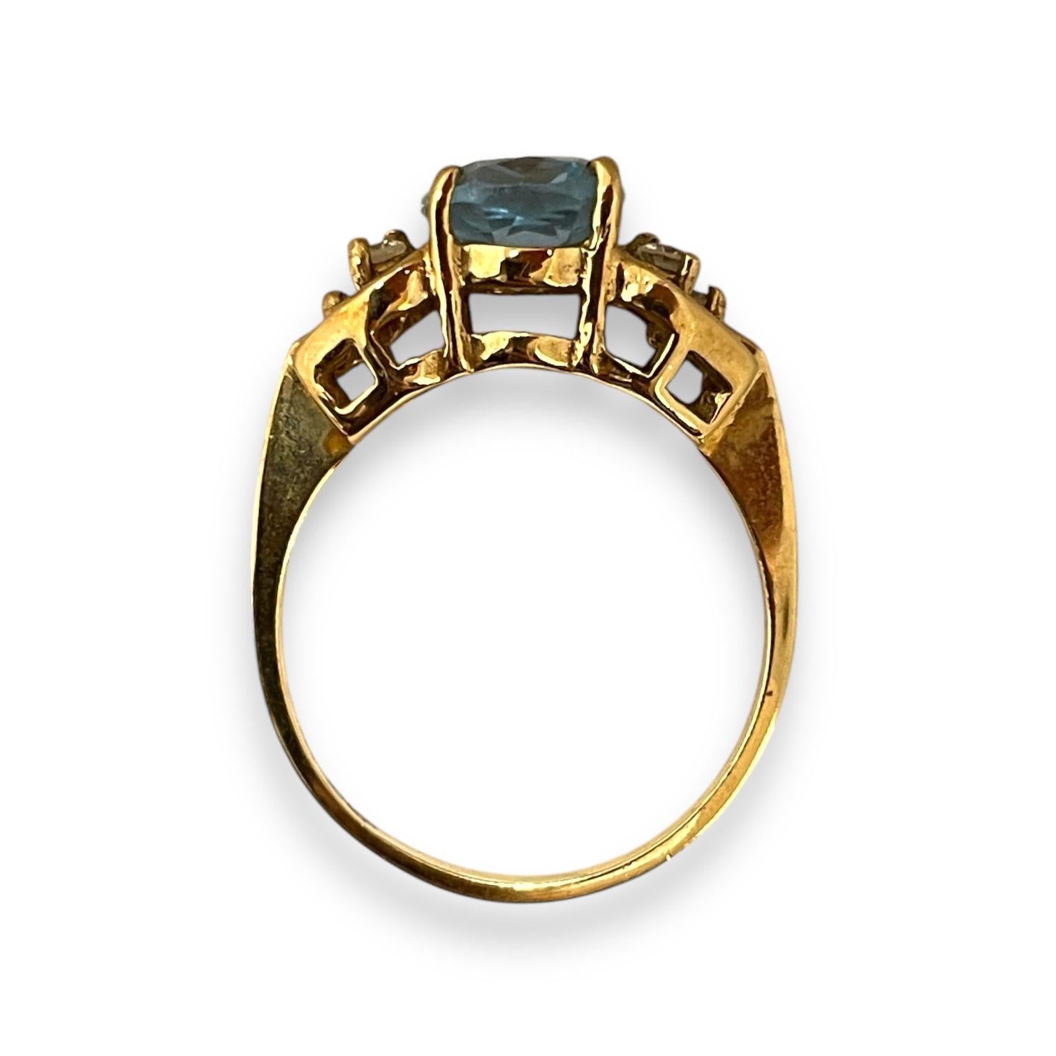 Un mélange étonnant de topaze bleue et de diamants scintillants sertis dans un luxueux or jaune. Le design complexe de cette bague met gracieusement en valeur la brillante topaze bleue, flanquée de délicats diamants, rayonnant d'élégance sous tous