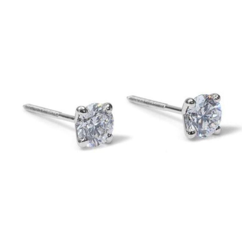 Embrace unparalleled elegance with these mesmerizing earrings featuring a magnificent 2 carat total weight of D color, VVS1 clarity, EX cut round brilliant diamonds. Set in gleaming 18K white gold, meticulously polished for exceptional shine, these