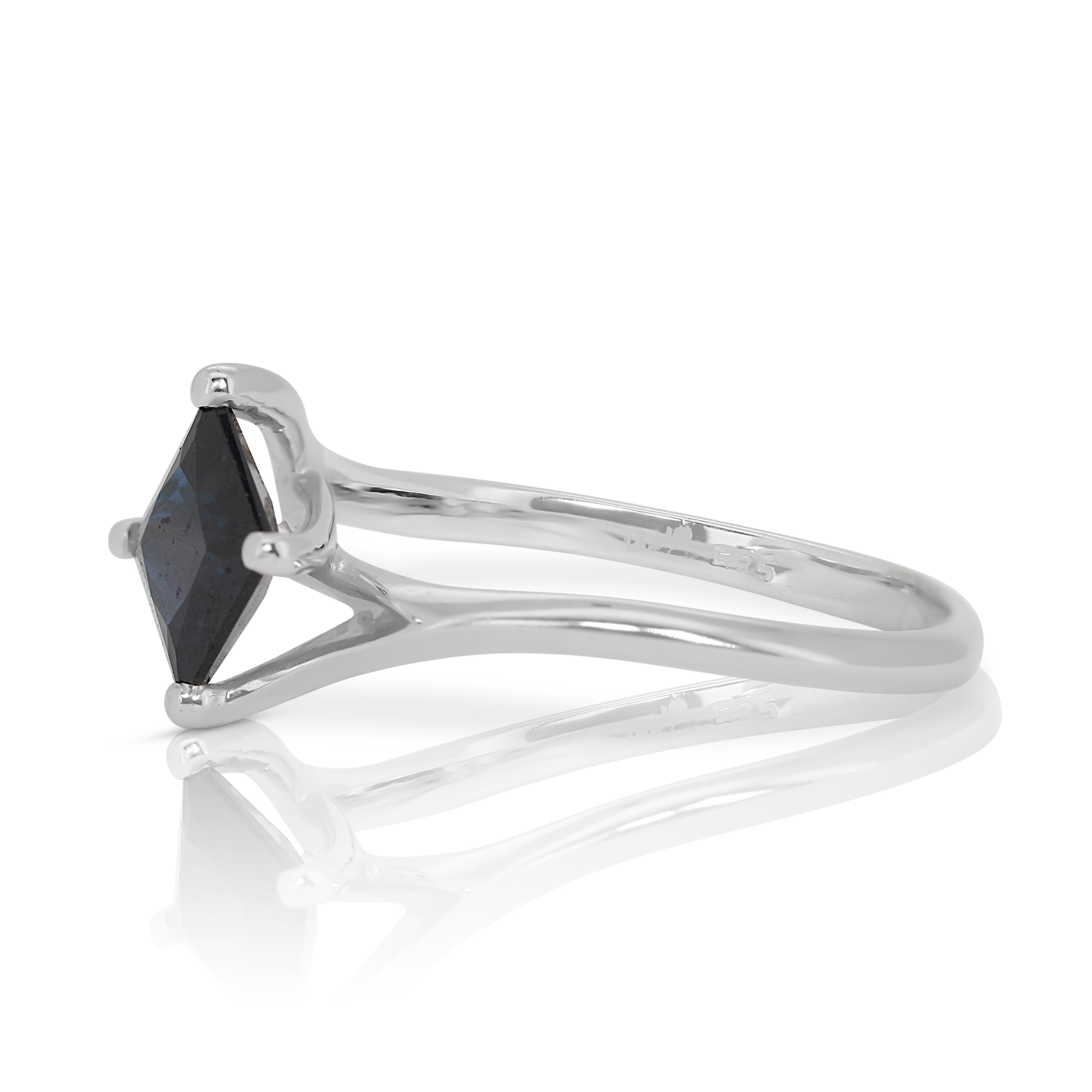 In der Mitte dieses exquisiten Rings sitzt ein faszinierender Saphir im Prinzess-Schliff mit einem Karatgewicht von 1,07ct. Der satte, dunkelblaue Farbton dieses prächtigen Edelsteins strahlt eine königliche Anziehungskraft und Raffinesse aus und