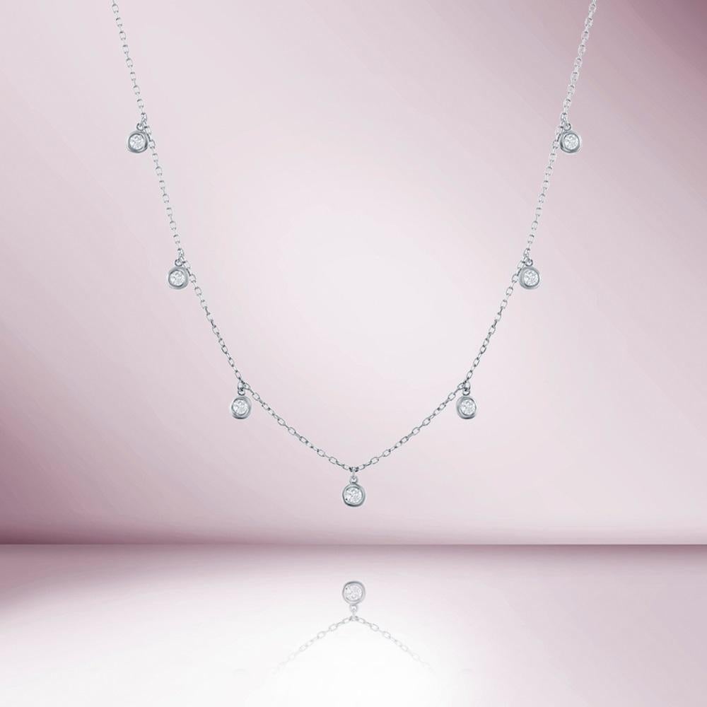Introducing our stunning 7 Stone Dangle Diamond Necklace, a beautiful addition to any jewelry collection. This necklace features a bezel set diamond station design, with 7 dazzling diamonds weighing a total of 0.50 carats. Each diamond is expertly