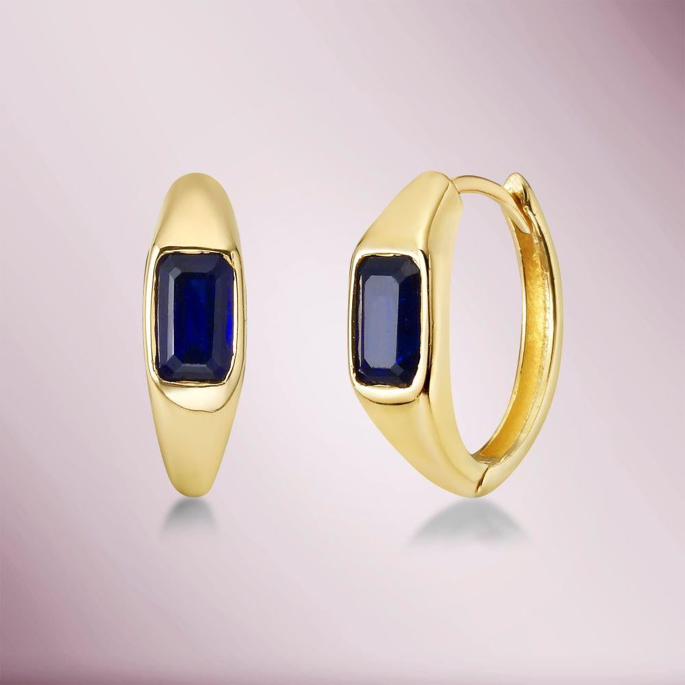 The Emerald Cut Blue Sapphire Huggies Earrings (1.00 ct.) in 14K Gold are a classic and versatile piece of jewelry that can be worn for both casual and formal occasions.
These earrings feature each an emerald cut ruby set in 14 karat gold. These