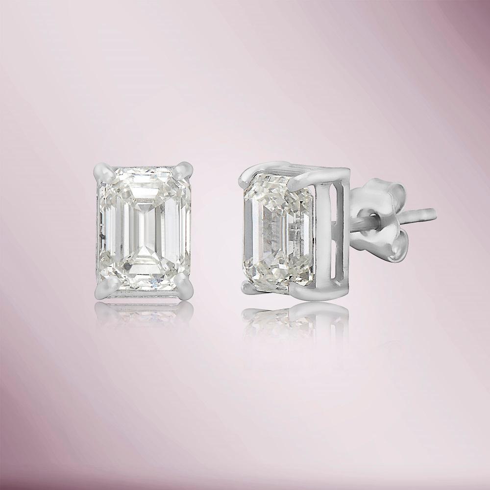 The Emerald Cut Diamond Rectangular Studs Earrings are a stunning and timeless addition to any jewelry collection. Featuring a pair of beautiful emerald-cut diamonds totaling 2.03 carats, each diamond is meticulously set in a classic and elegant