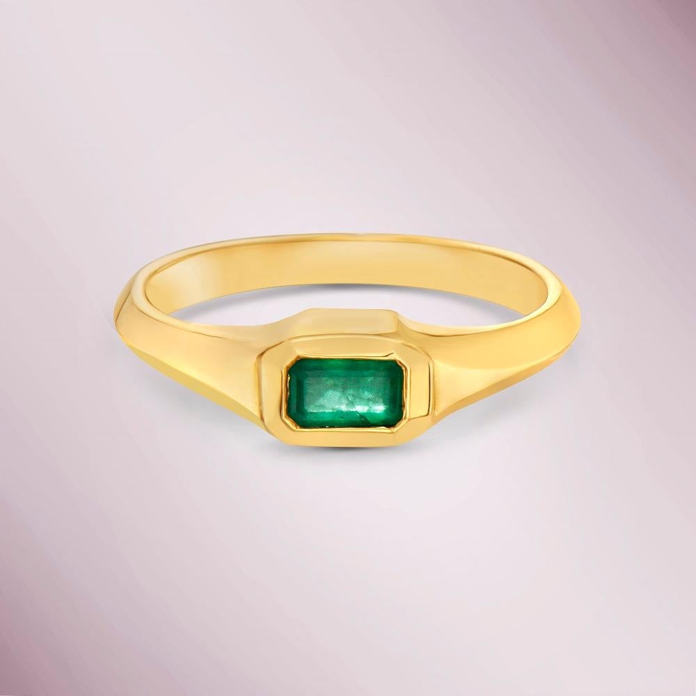 The Emerald Cut Emerald Solitaire Ring (0.25 ct.) Bezel Set in 14K Gold is a beautiful and elegant piece of jewelry that features a single emerald cut emerald as its centerpiece.

The emerald has a weight of 0.25 carats and is cut in a rectangular