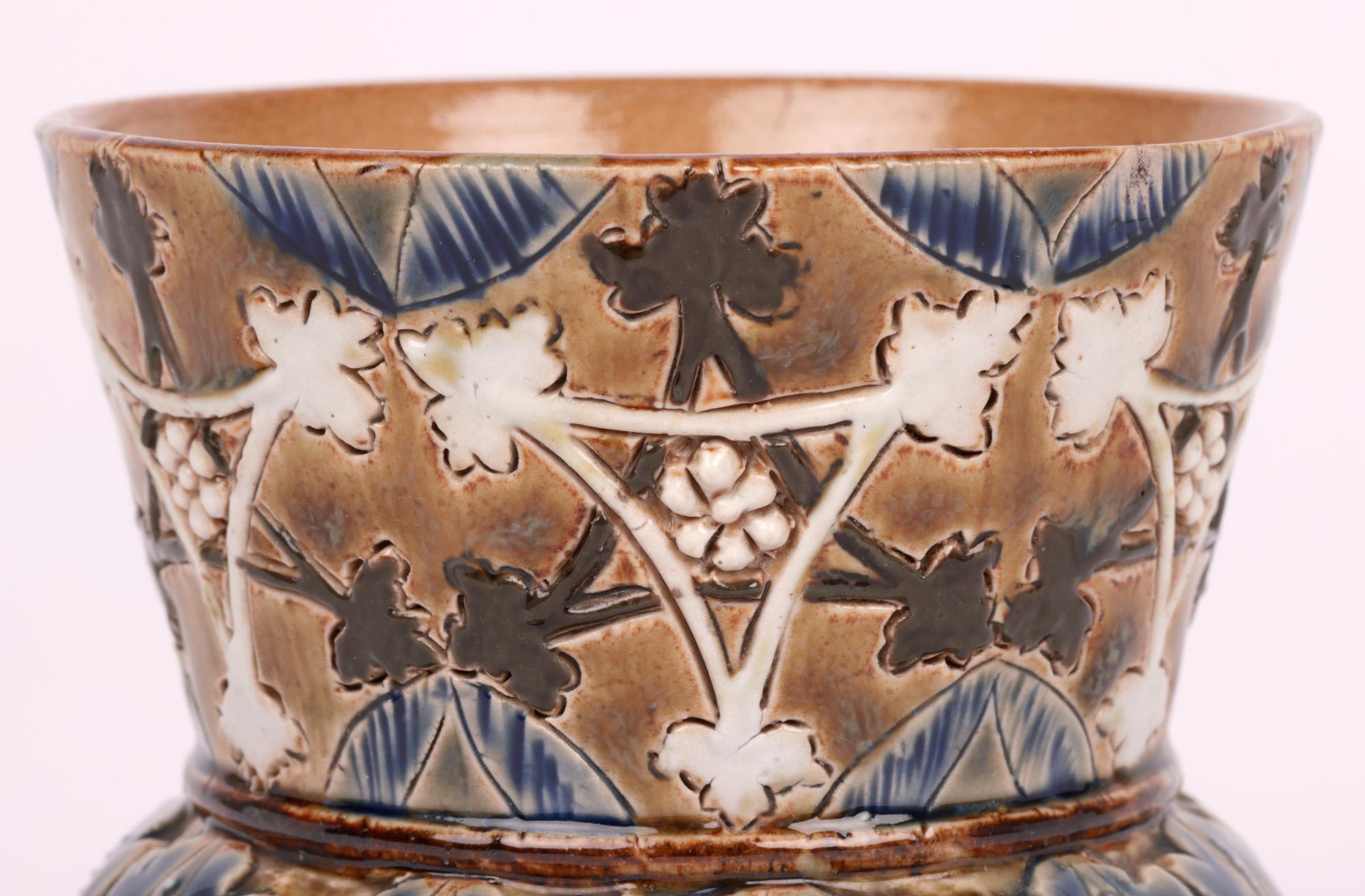 A delightful Doulton Lambeth aesthetic movement thistle shaped vase applied with stylized leaf and floral designs by Clara Baker and dated 1878. This nice early stoneware vase stands raised on three small round column shape legs with shallow round