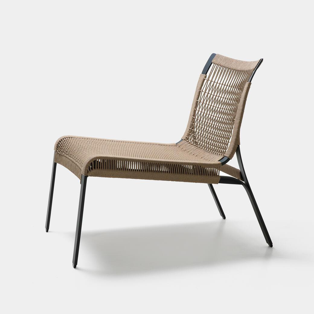 Suited for both indoor and outdoor use, the chair is crafted with a lightweight metal frame and beautiful tight weaving that forms a pattern across the back. With deep, inviting proportions, it makes for a visually striking chair that blends with