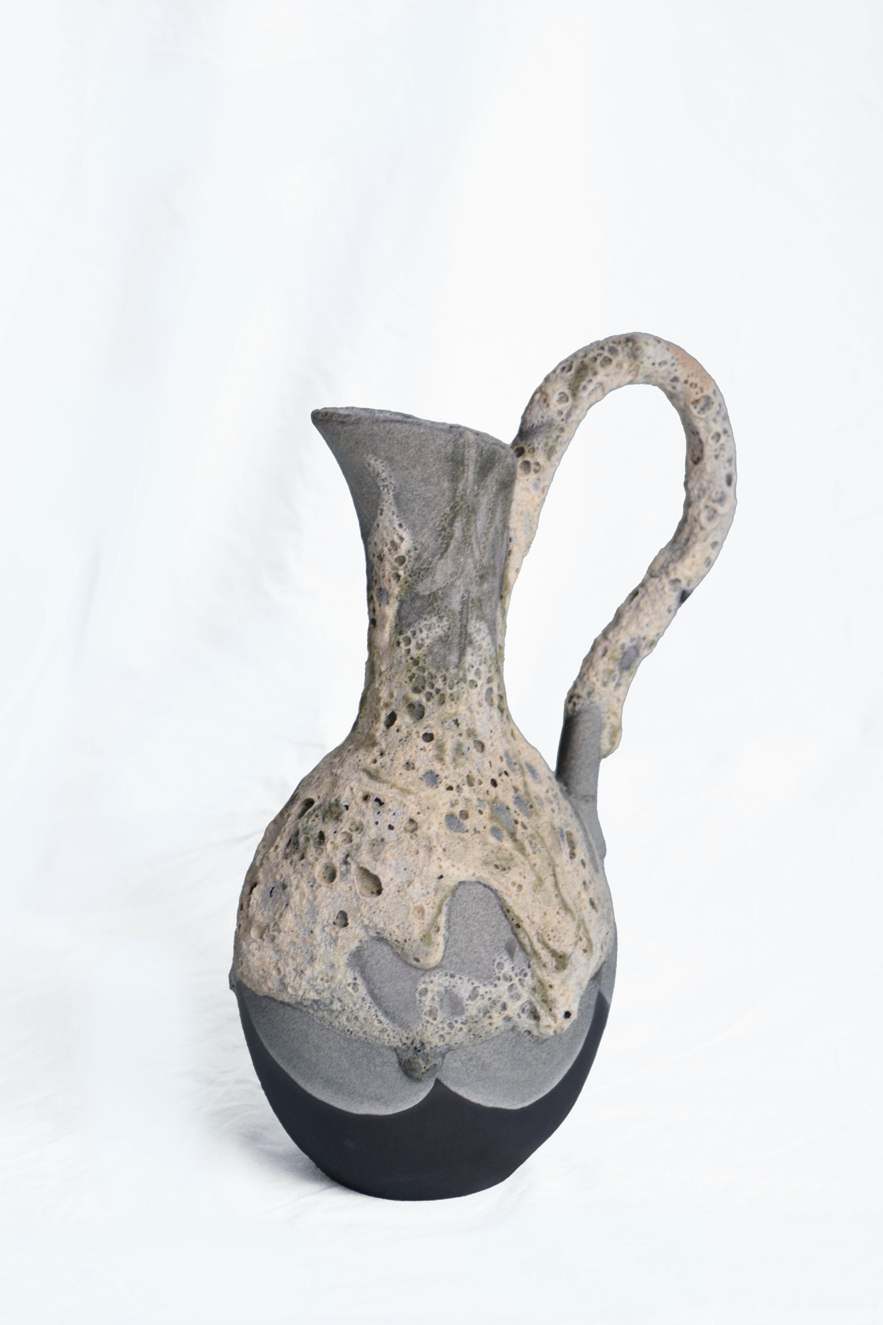 Carafe 2 vase by Anna Karountzou
Dimensions: W 21 x D 14 x H 34 cm
Materials: black stoneware clay, clear glaze inside, handmade crater glaze outside, fired at 1220

Born and based in Athens, Greece, with a background in conservation of works of