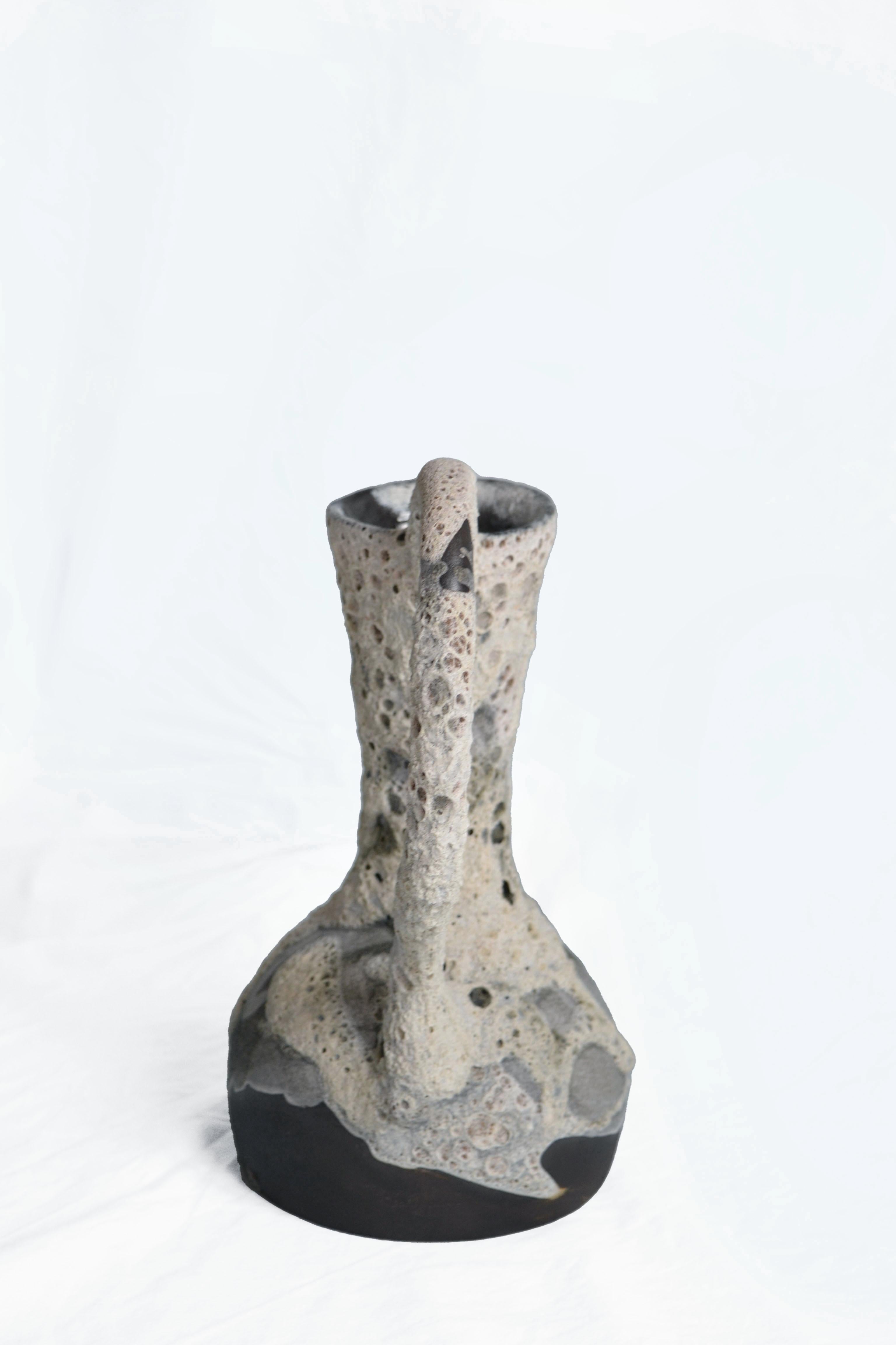 Carafe 6 vase by Anna Karountzou
Dimensions: W 21.5 x D 15 x H 30 cm
Materials: black stoneware clay, clear glaze inside, handmade crater glaze outside, fired at 1220

Born and based in Athens, Greece, with a background in conservation of works