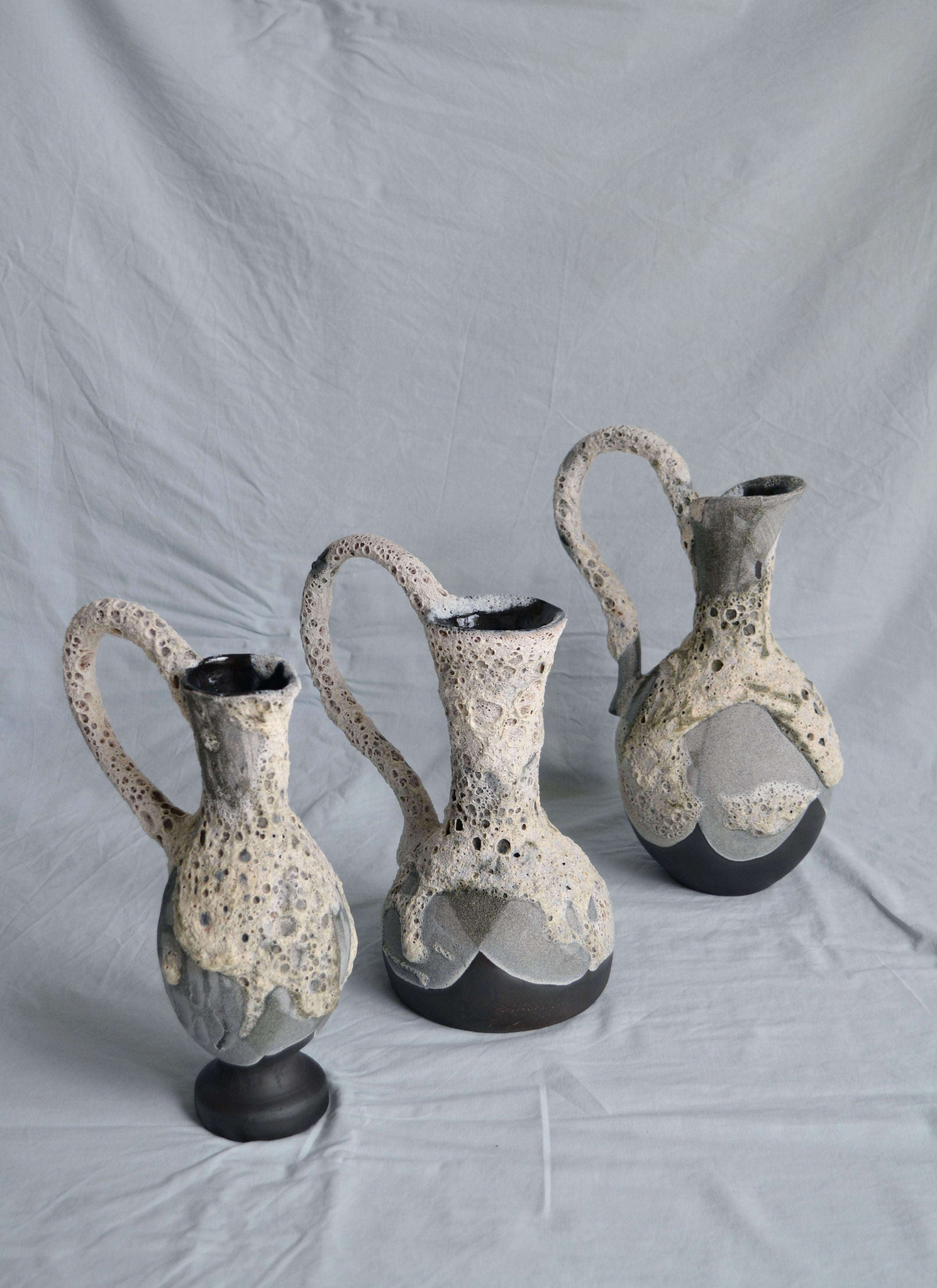 Carafe 7 vase by Anna Karountzou
Dimensions: W 15.5 x D 14.5 x H 32 cm
Materials: black stoneware clay, clear glaze inside, handmade crater glaze outside, fired at 1220

Born and based in Athens, Greece, with a background in conservation of