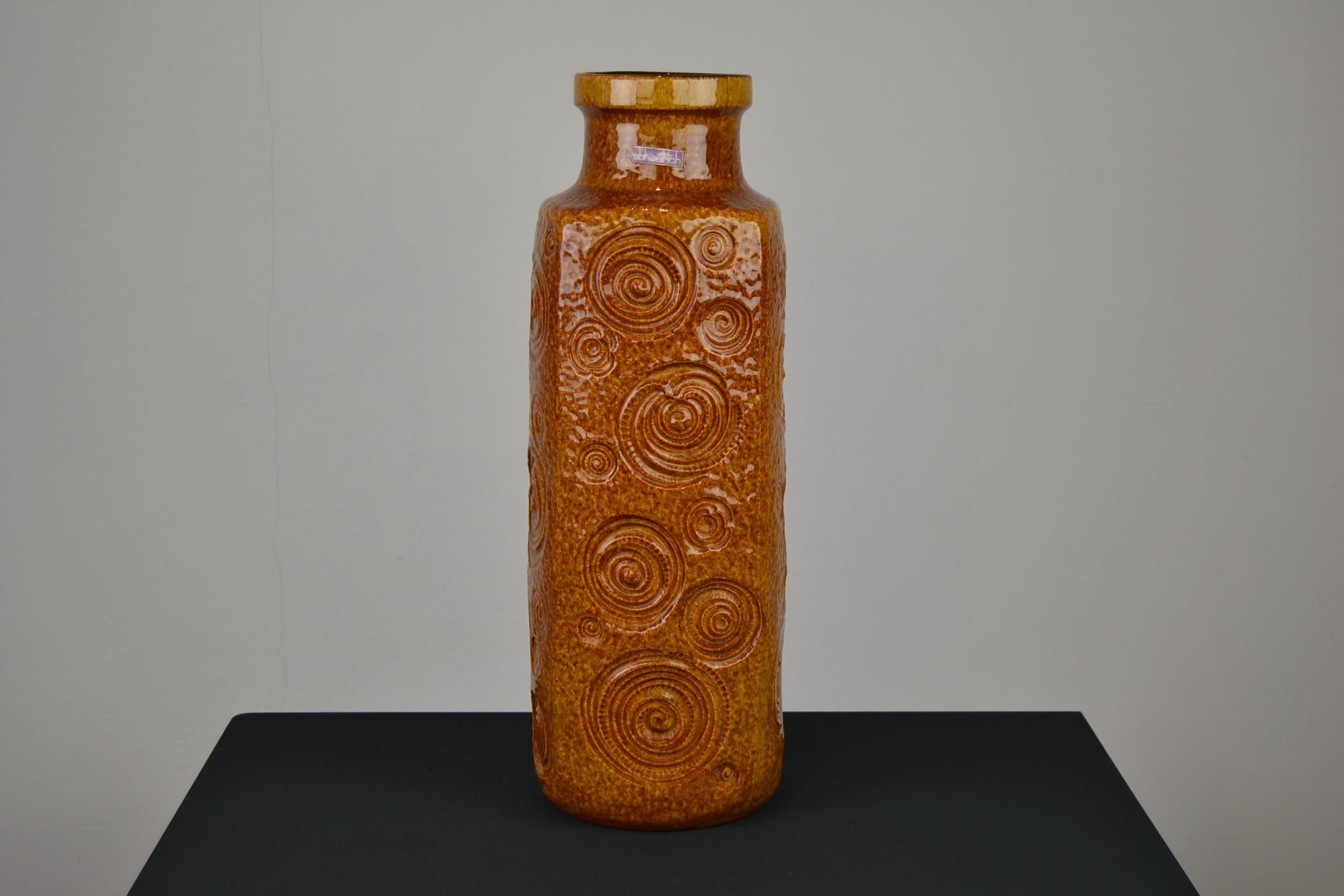 Caramel brown floor vase by Scheurich, Western Germany.
This 1970s fat lava art pottery vase is marked 282-53, Western Germany. 

A beautiful vase with beautiful design, circles all around on the vase.
If you would see white spots on the