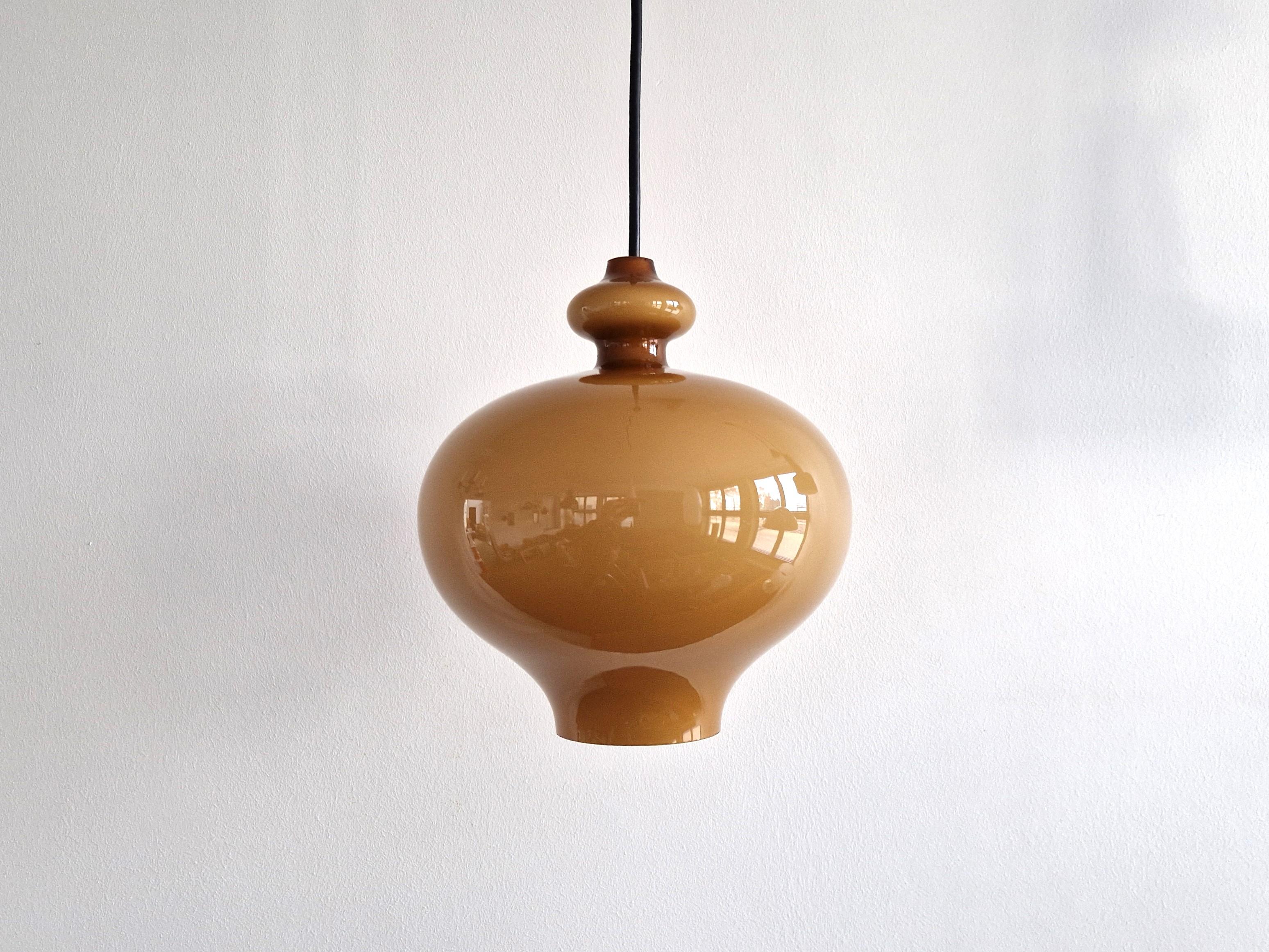Cette magnifique lampe suspendue en verre de forme ronde a été conçue par Hans Agnes Jakobsson pour Staff Leuchten dans les années 1970. Il s'agit d'un abat-jour en verre de couleur brun caramel chaud avec un intérieur opalin pour une belle lumière