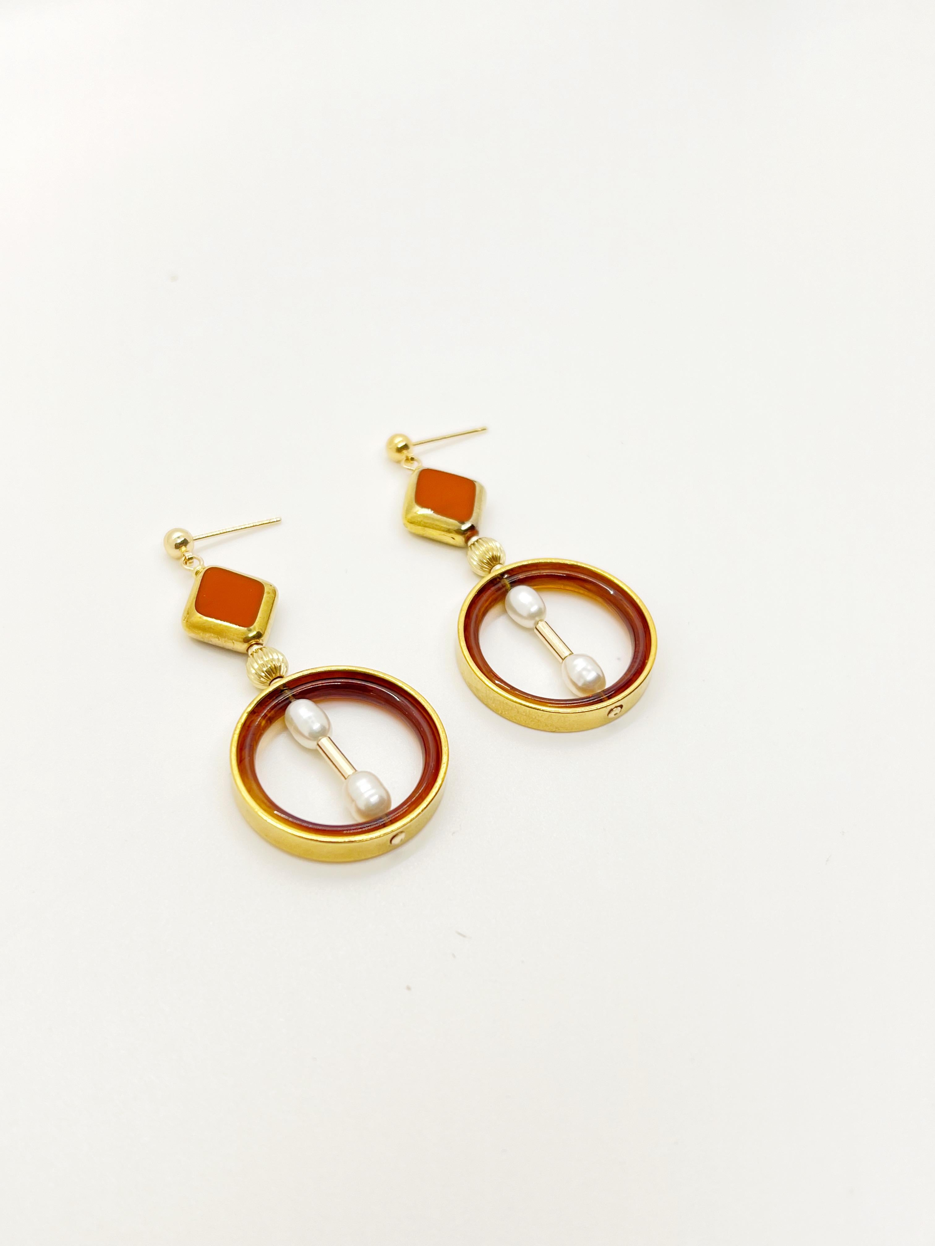 Each earring consist of Caramel colored vintage German glass beads edged with gold, vintage lucite, freshwater pearls, brass metal plated with 24K gold, gold-filled findings and ear stud. 

The vintage German glass beads were hand pressed during the