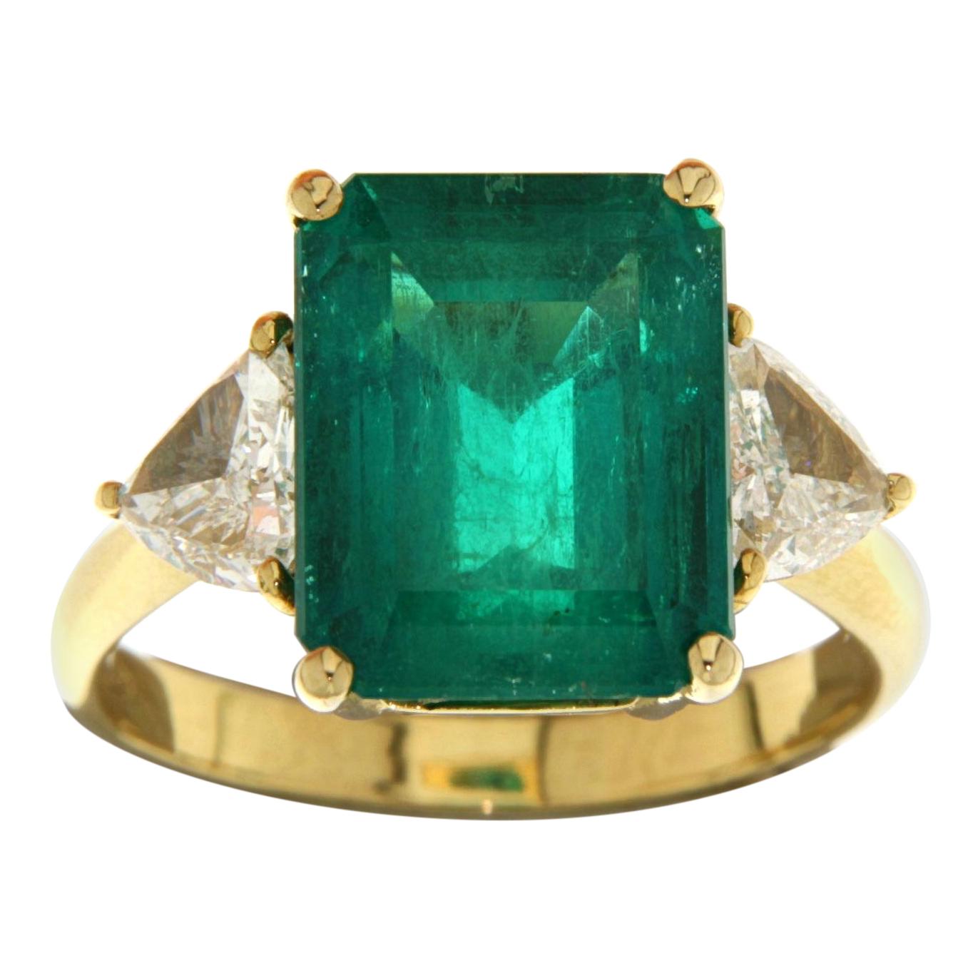 18kt yellow gold Ring 6.75ct Minor Emerald Colombia, Triangle Diamonds,  CGL

Golden ring with large emerald and triangle diamonds.

Emerald: 6.75 ct Colombia,Minor oil, Beryl, Octagonal/ step cut, green emerald stone. Measurements 12.55 x 9.88 x