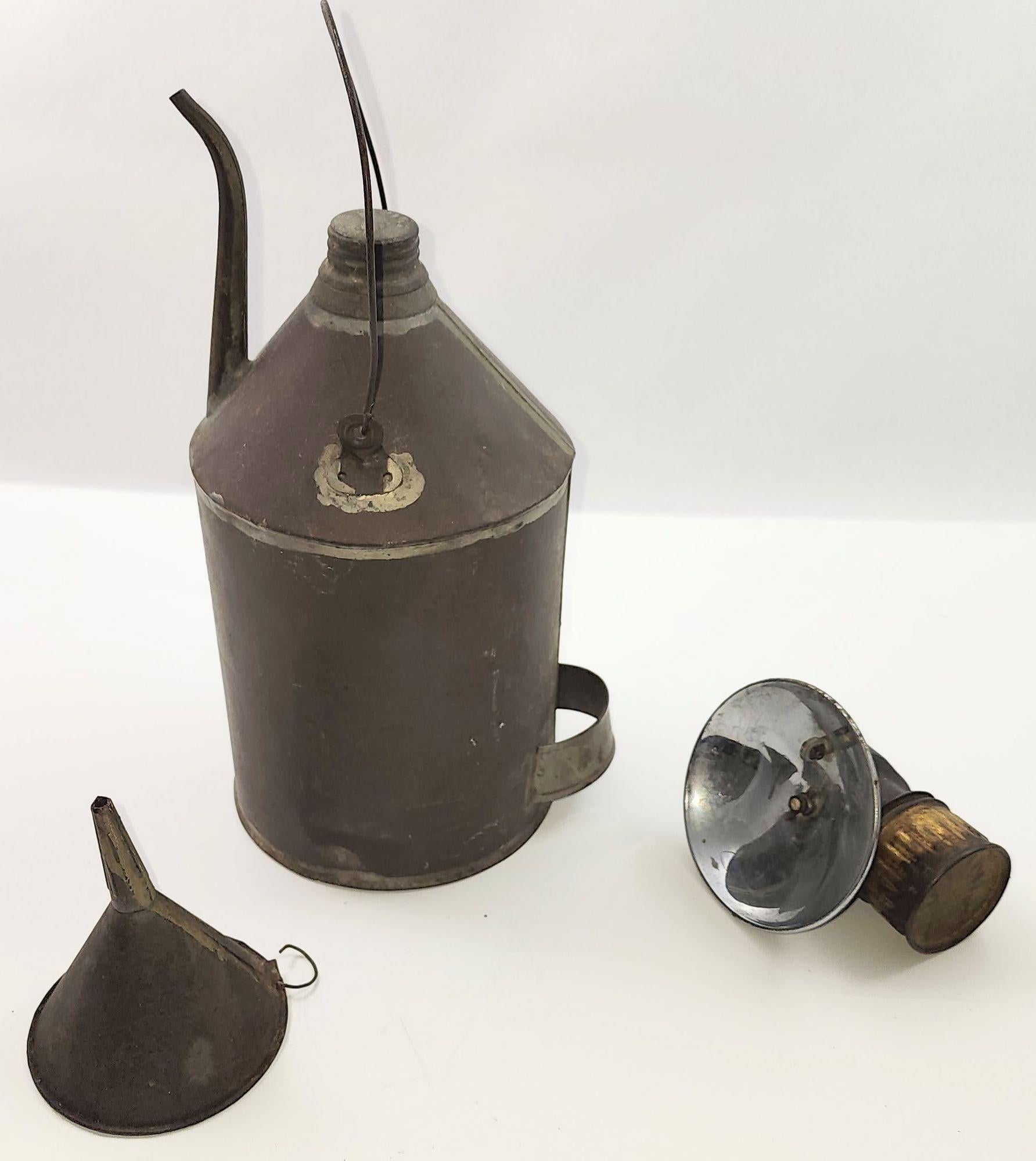 Ancienne lampe de mineur de charbon en carbure de Justrite, datant des années 1900, conçue pour être portée sur un casque, avec un bidon d'huile de charbon et un entonnoir en fer-blanc. Fabriquées à la main par la célèbre Justrite Manufacturing