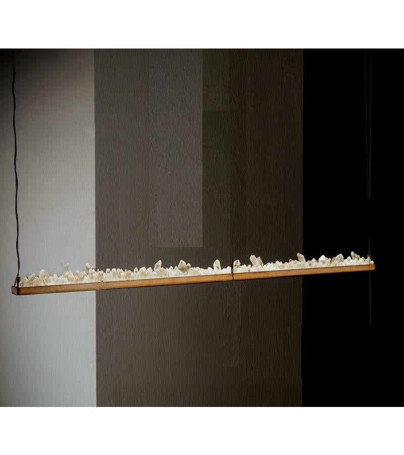 Lampada a sospensione Quartz horizontal 120 di Aver 
Firmato da Waldir Junior
Dimensioni: D 5 x L 124 x H 8 cm 
Materiali: Alluminio, finitura bronzo antico. Quarzo bianco naturale e quarzo fumé.
Illuminazione: 01 x 20W LED 1600 lumen.
Finitura: