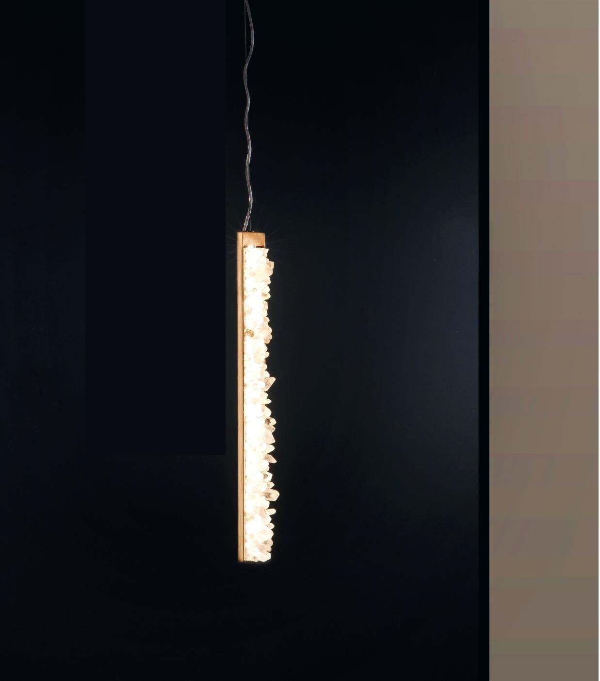 Lampada a sospensione verticale Quartz di Aver 
Firmato da Waldir Junior
Dimensioni: P 10 x L 5 x H 62 cm 
Materiali: Alluminio, finitura bronzo antico. Quarzo bianco naturale e quarzo fumé.
Illuminazione: 01 x 10W LED 800 lumen.
Finitura: