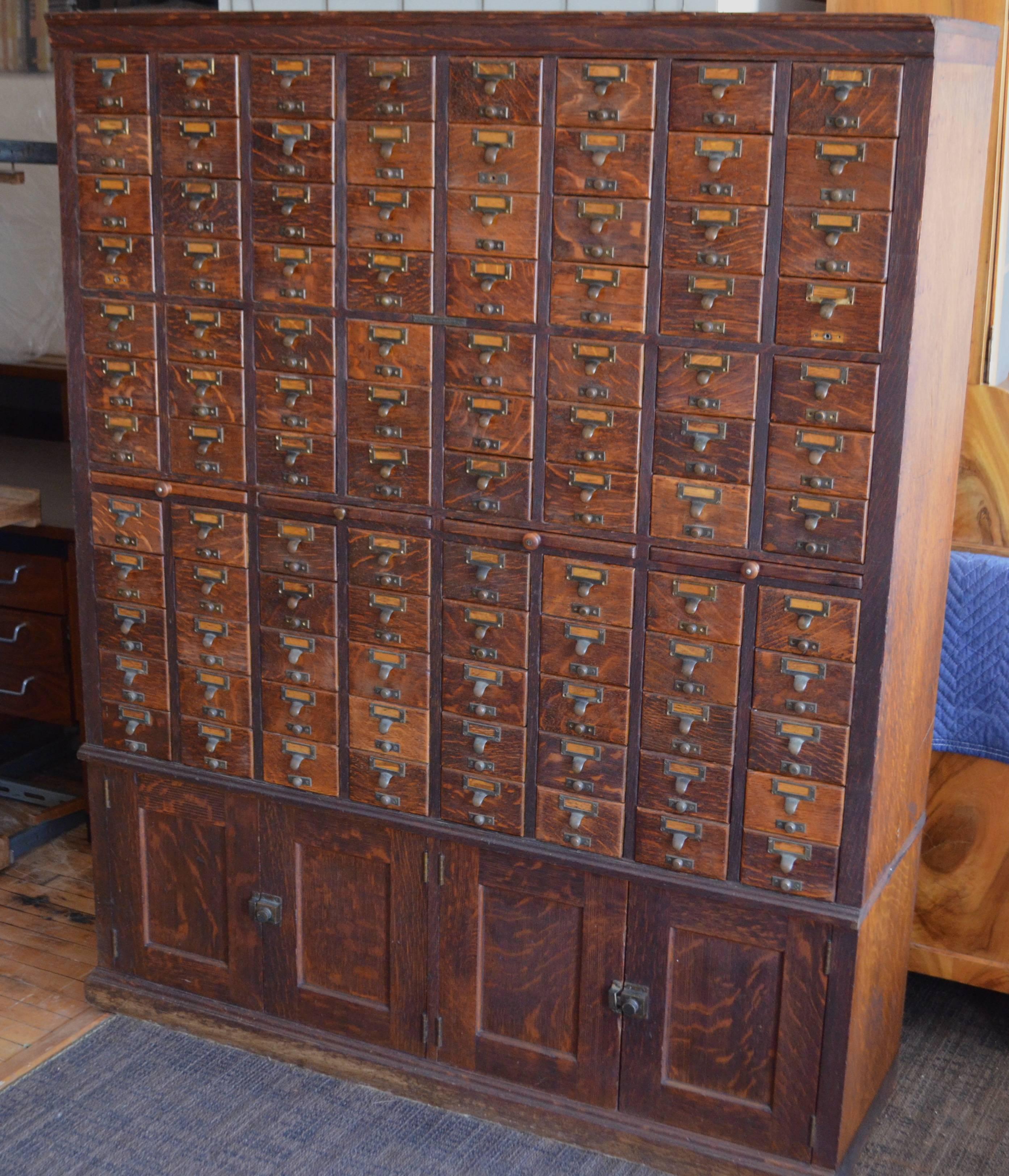 Card catalog, file cabinet, solid oak from Chicago library, early 20th century. 96 drawers with brass pulls and two lower compartments. Totally restored maintaining wonderful varnished patina of drawer fronts. An iconic piece. Internal dimensions of