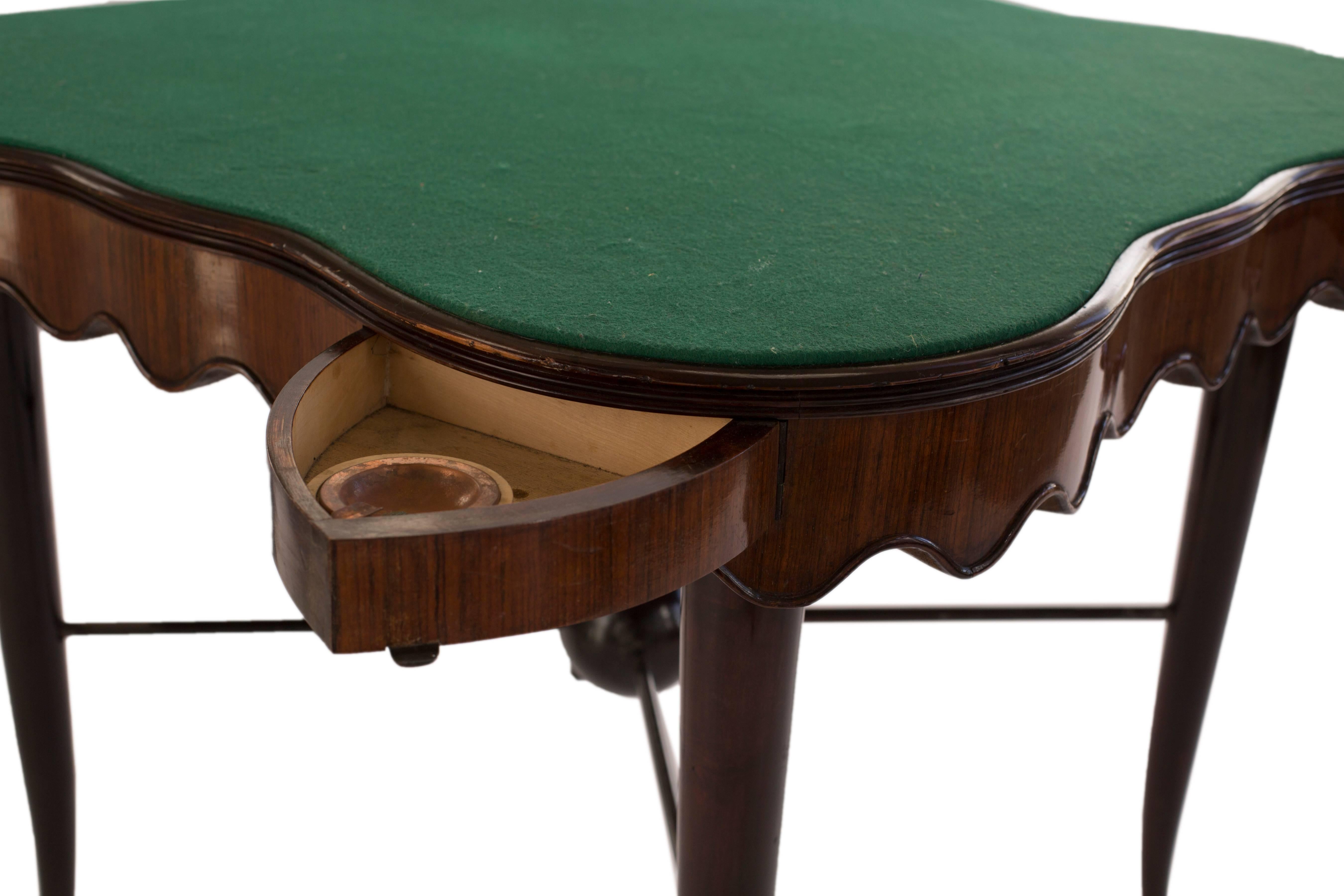 Unusual Art Deco continental gaming table. It's undulating freeze reveals an integral drawer to each corner. The ebonized sable type legs are met with an 'X' frame stretcher terminating in a central spherical boss.