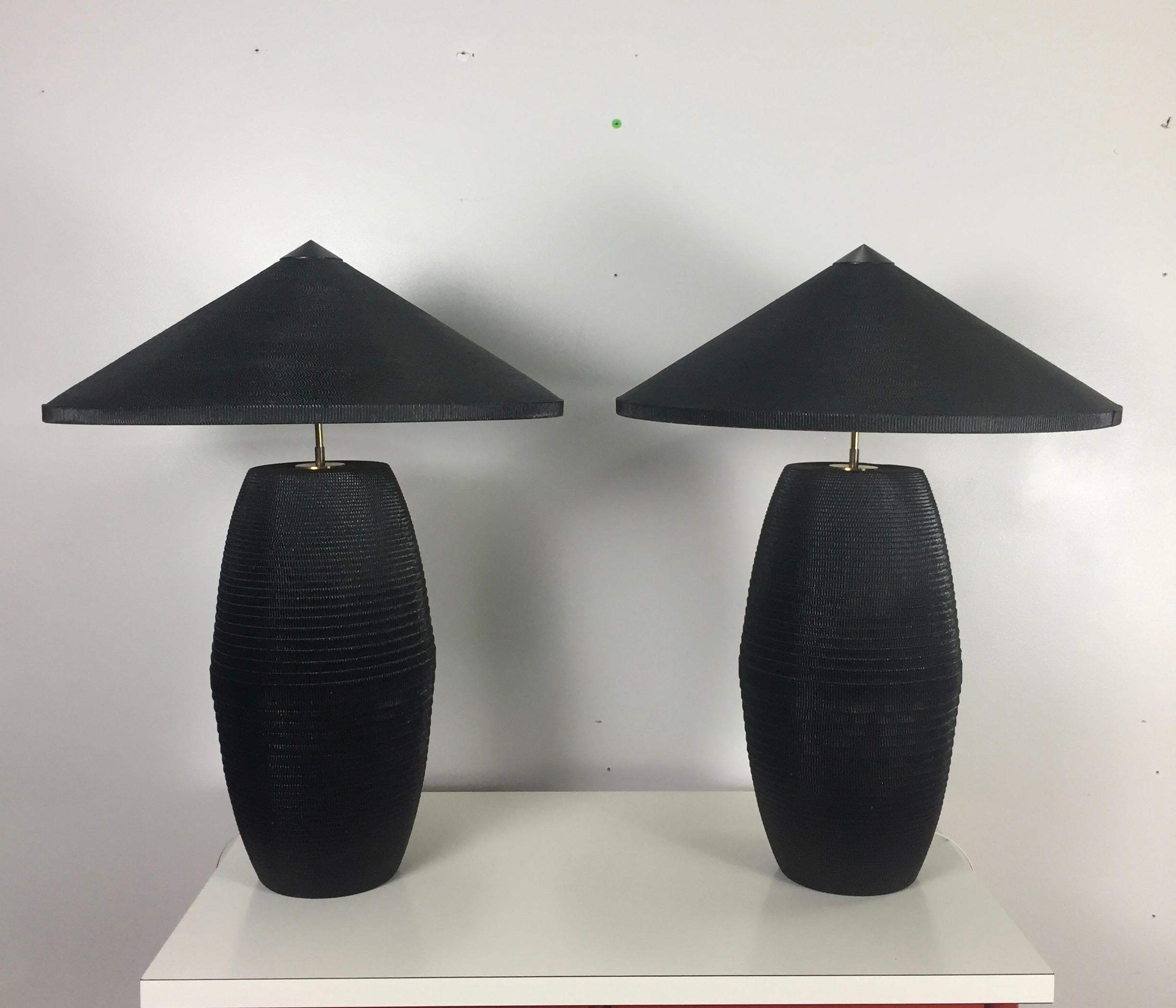 This pair of exceptional lamps complete with original shades is most likely from the 1980s or 1990s. Produced from wrapped corrugated cardboard these lamps have a lovely column shape with an Asian inspired theme to the shades. The shades are cut
