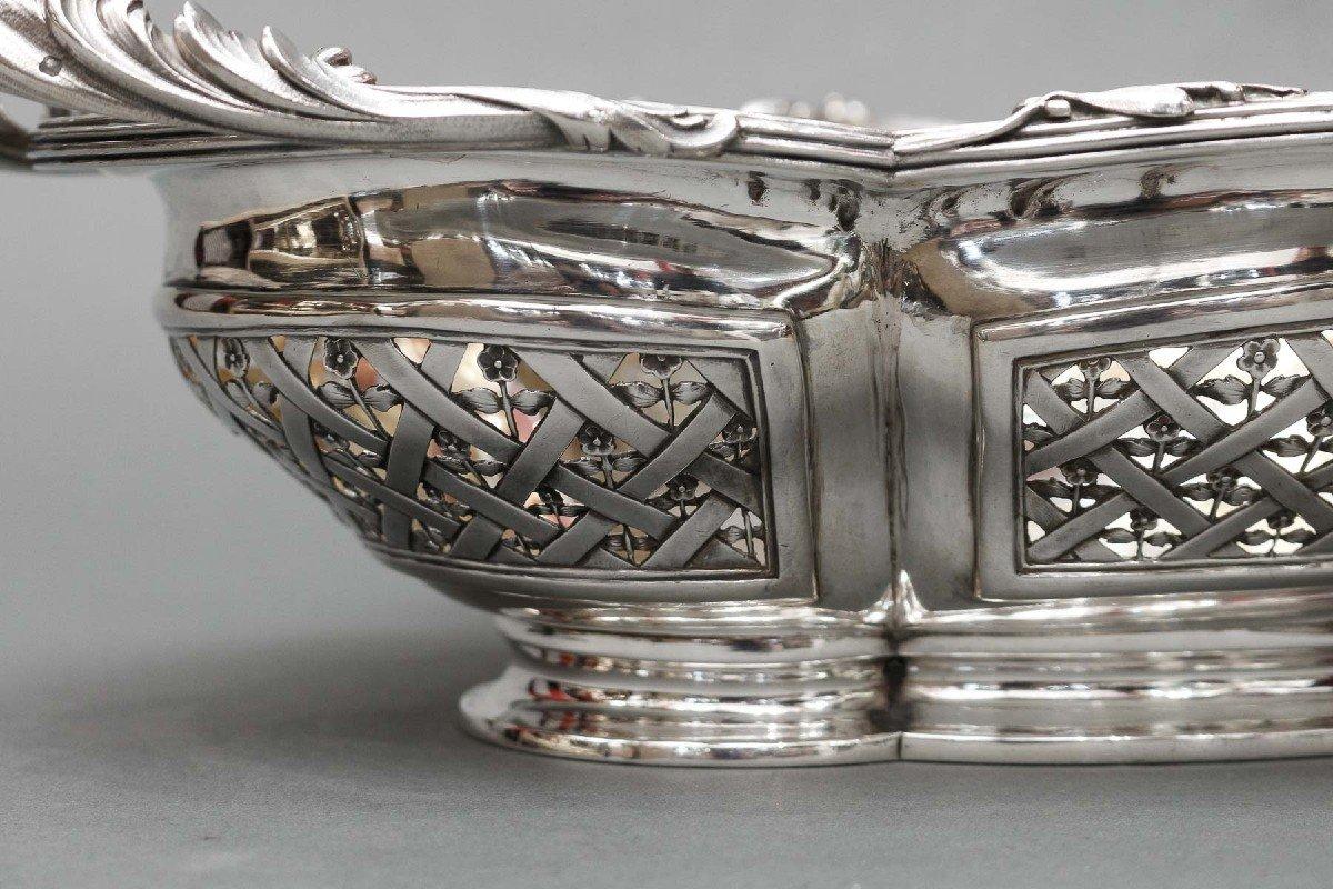 Large multi-lobed fruit basket in solid silver decorated with foliage and clasps. The body is openwork and pierced with canework decorated with a seedling of flowers, flanked on each side by handles in the shape of acanthus leaves and resting on a
