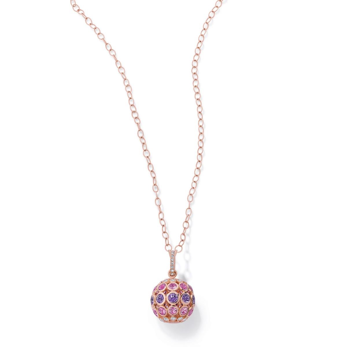 This 18 karat rose gold Carelle Disco Dots color sapphire ball pendant captivates with an oversized silhouette, hanging from an elegant gold chain. The disco ball shimmers with geometric opulence featuring round purple and pink sapphires, totaling