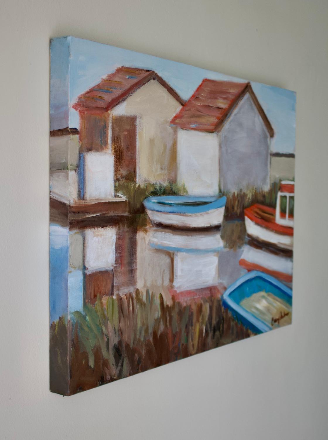 <p>Artist Comments<br>Fishing huts stand along a channel, with oyster boats docked on the side. Their gentle reflections mirror almost perfectly on the still water. The muted palette with vibrant blue and orange accents and soft strokes conveys the