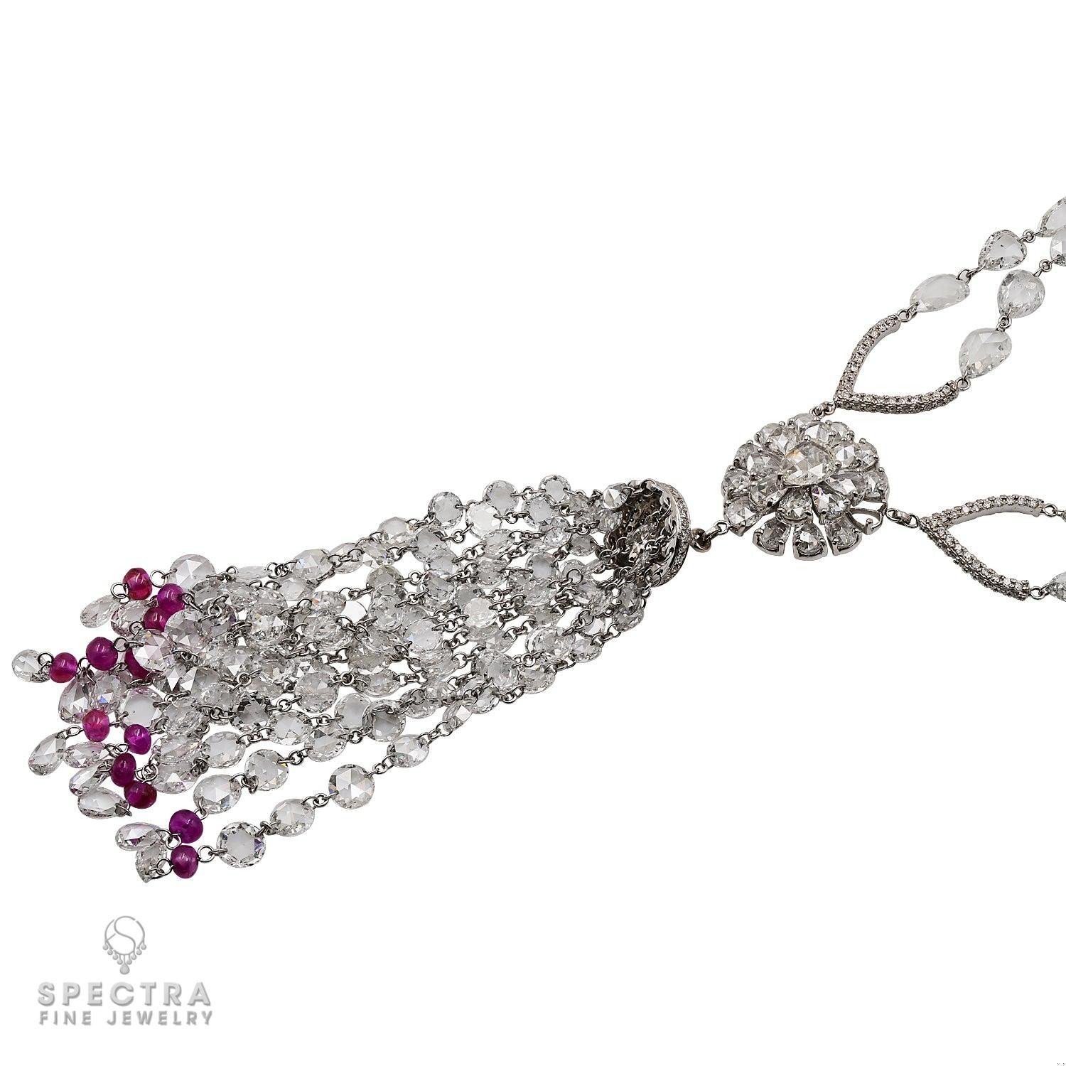 Presenting the Carezza Ruby Diamond Tassel Necklace, a true symbol of elegance and luxury. This exceptional piece showcases an exquisite array of diamonds, all artfully set in 18k white gold.

At the heart of this necklace lies an awe-inspiring