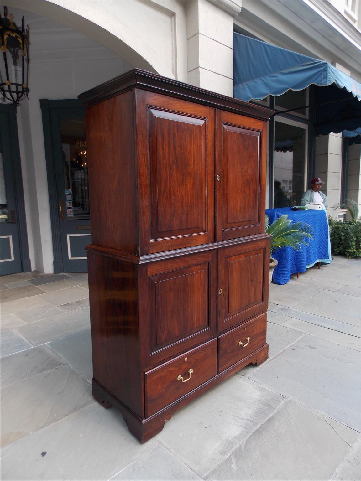 Caribbean Zebra wood gentleman's linen press with a carved molded edge cornice, two upper beveled paneled hinged doors revealing two adjustable interior shelves, two lower beveled hinged doors revealing two fitted interior drawers, flanking lower