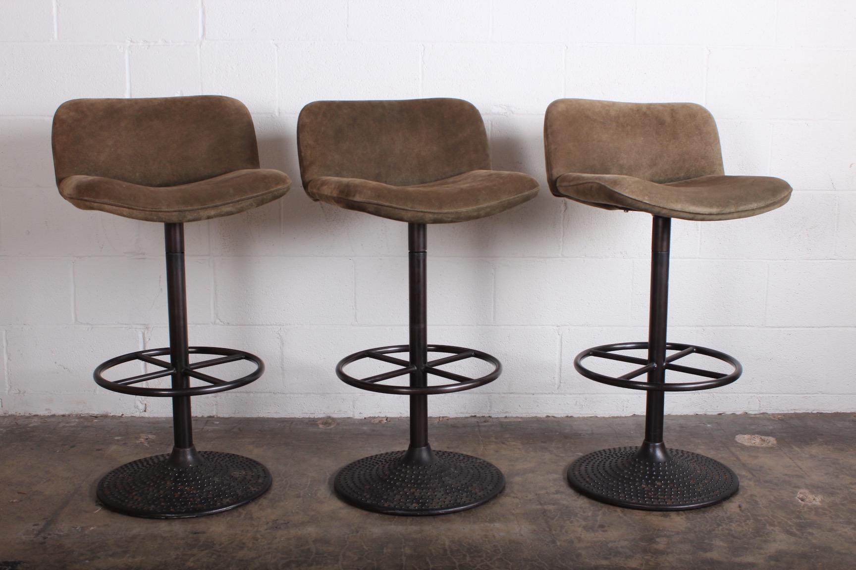 A set of three swiveling barstools in steel and original suede designed by Ilmari Tapiovaara.