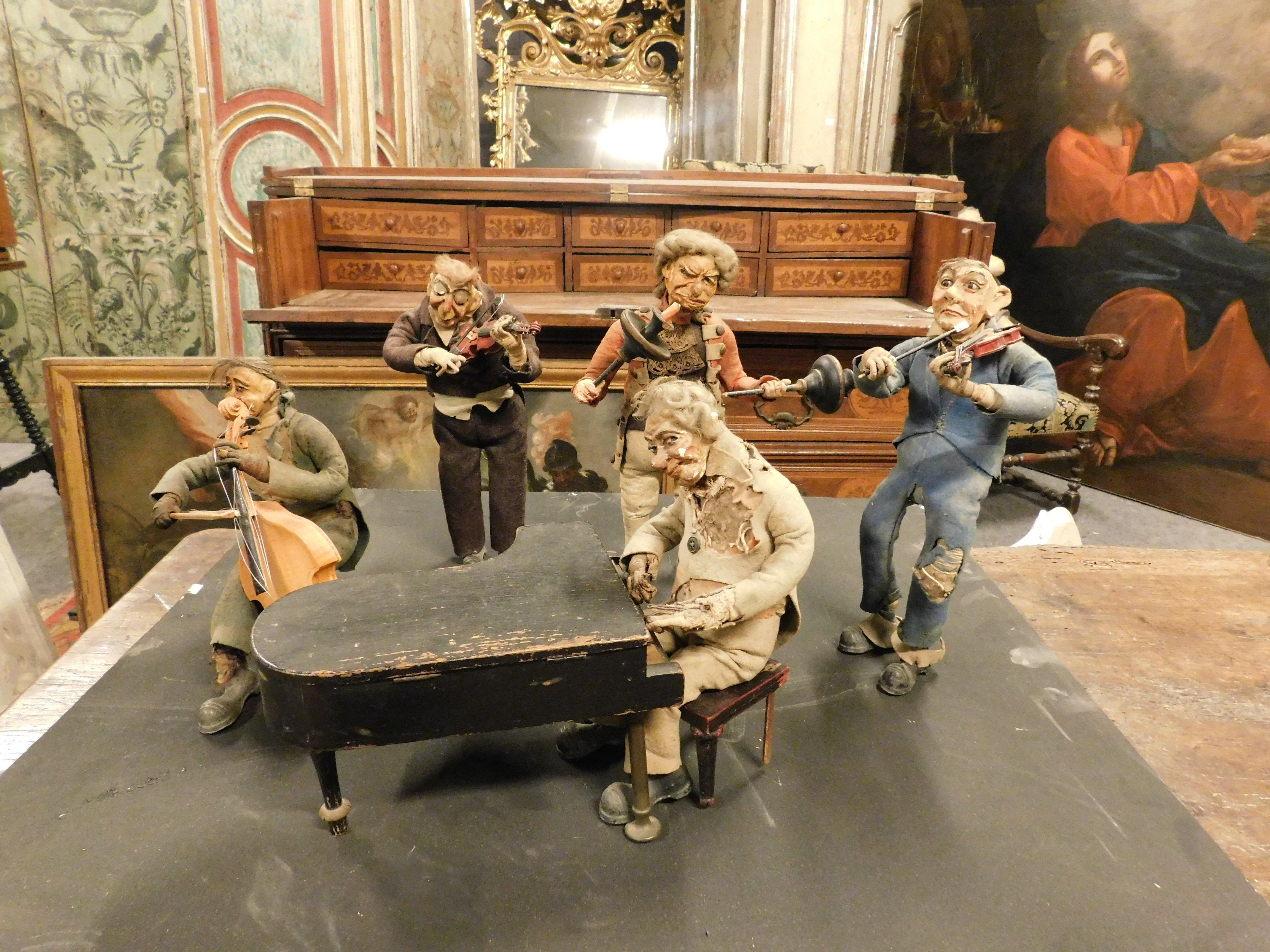 Incredible and very rare set of five antiques piece musicians, built with a fabric body and iron feet to ensure stability, hand-painted papier-mâché head, the piano is a functioning music box, so it also plays, hand-built in Italy for theater or as