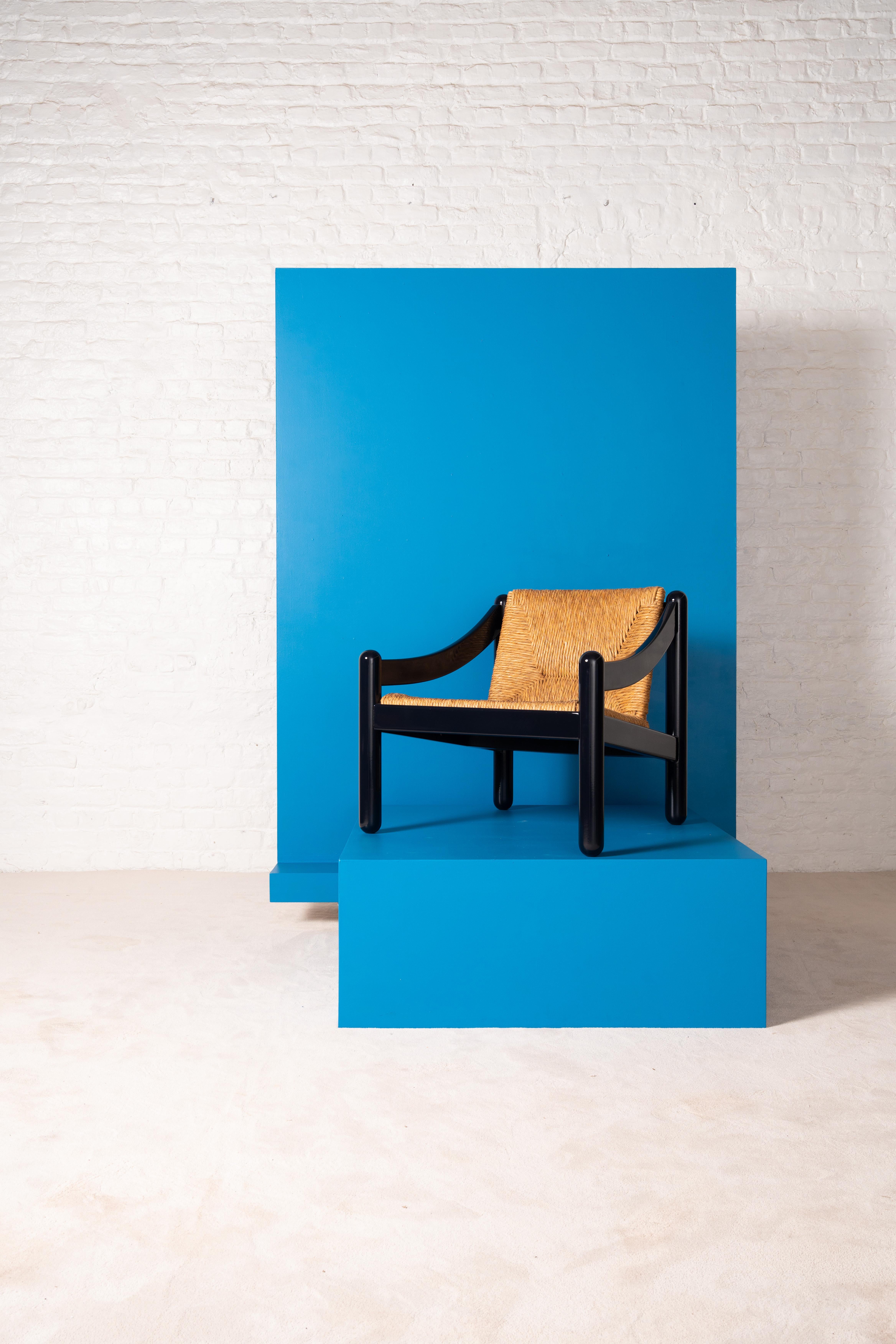 Icono del diseño italiano, el sillón Carimate 930 combina una estructura de madera maciza lacada con un asiento de paja tejida a mano. Diseñada por Vico Magistretti para la Casa-Club de Golf Carimate para Cassina en los años 60, destaca por sus